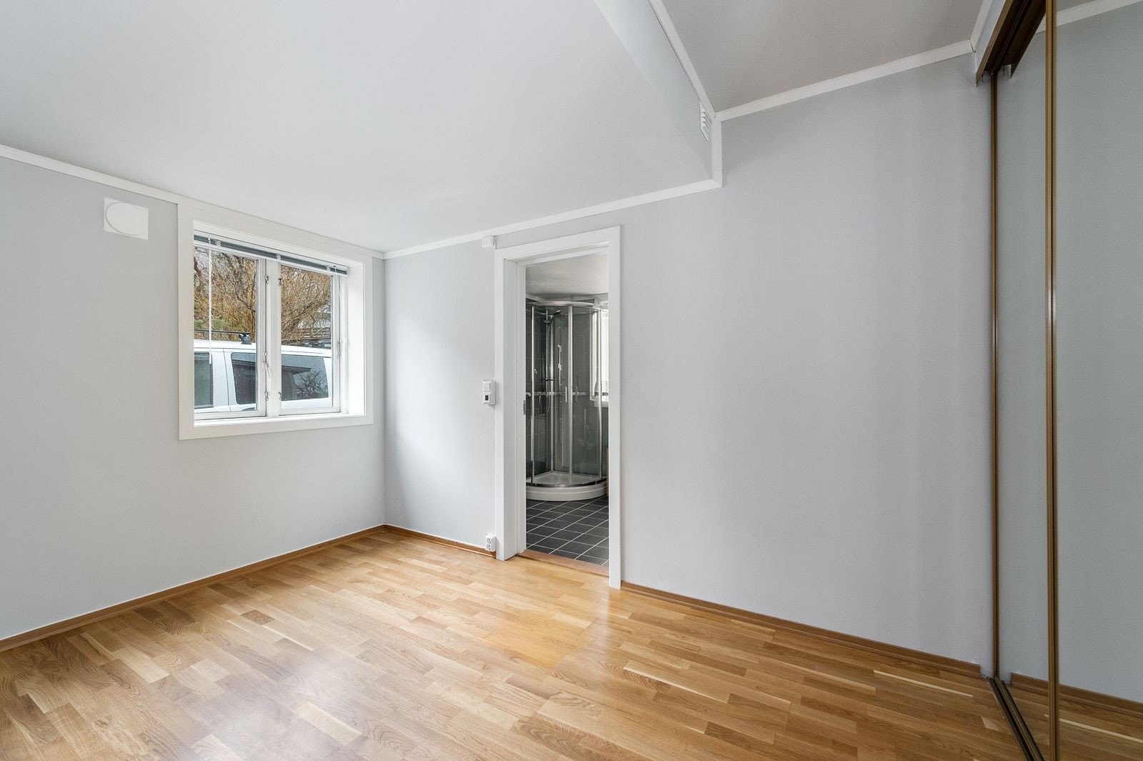 Soverom med skyvedørsgarderobe og inngang til badet Galleribilde