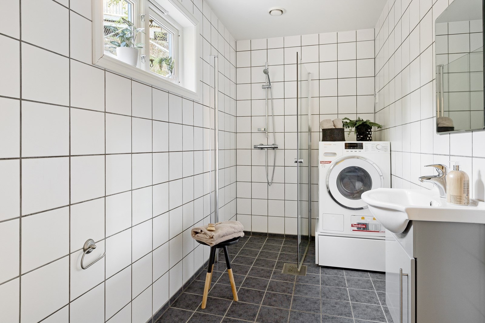 Badet har fliser på både gulv og vegger, og er utstyrt med mekanisk avtrekk samt opplegg for vaskemaskin. Galleribilde