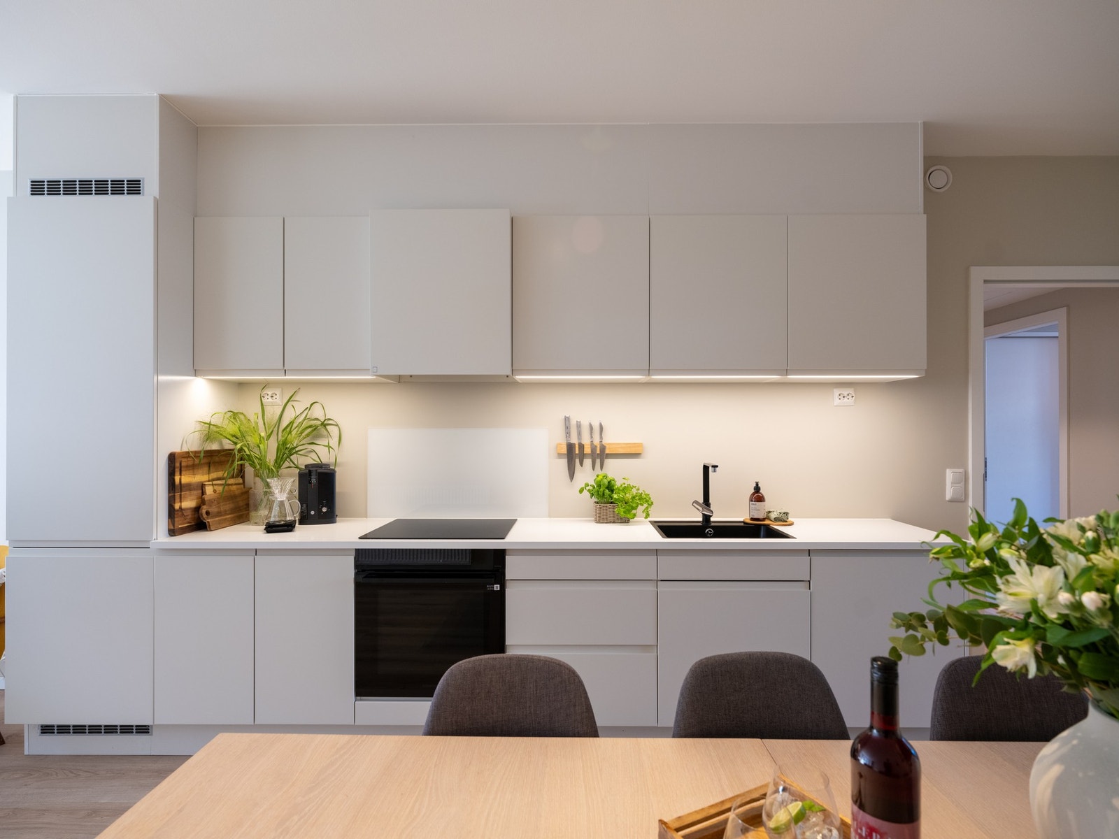 Lys, glatt innredning med laminat benkeplate og nedfelt oppvaskkum. Galleribilde