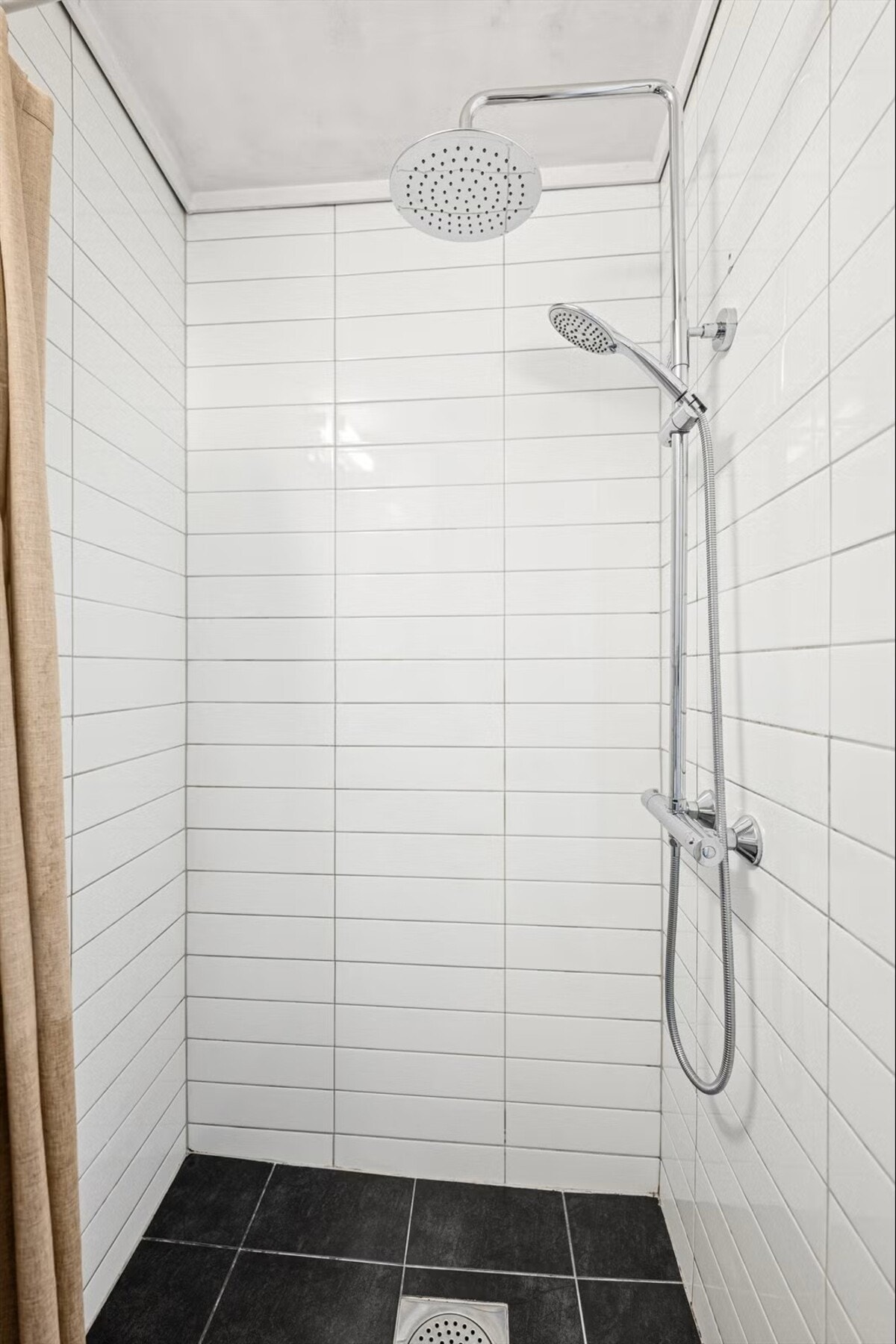 Badet er praktisk innredet med dusjnisje, vegghengt speil, servant og toalett. Galleribilde