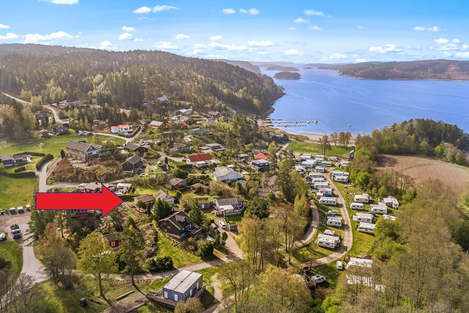 Ligger til Tosekilen og ser man både sandstrand og bryggeanlegg. Galleribilde