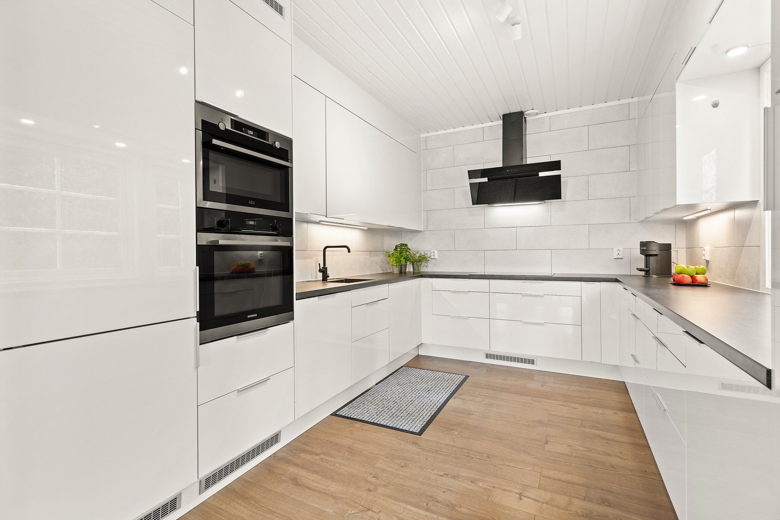Kjøkken har hvite glatte fronter og laminert benkeplate. Galleribilde
