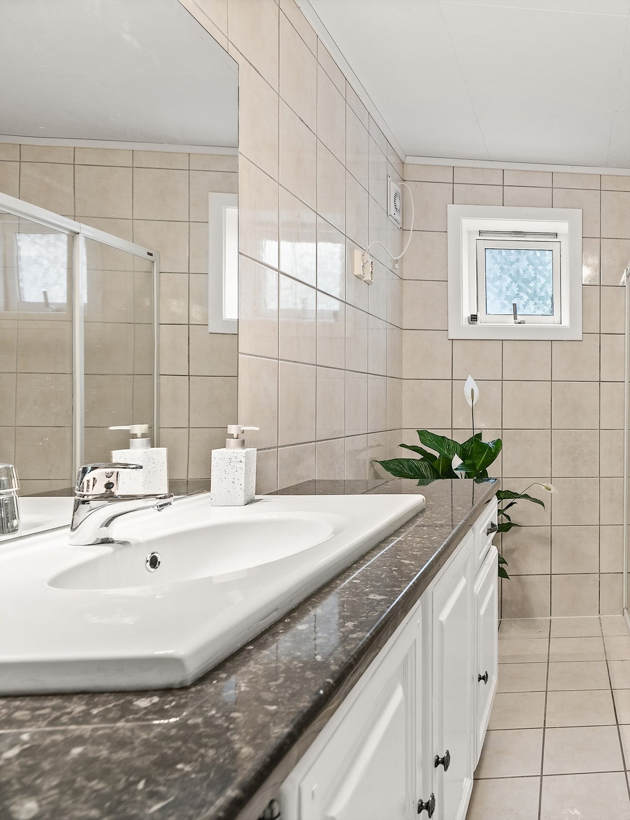 Badet har vegghengt servant med ovenpåliggende servant og ett-greps armatur. Her er det også opplegg for vaskemaskin. Galleribilde