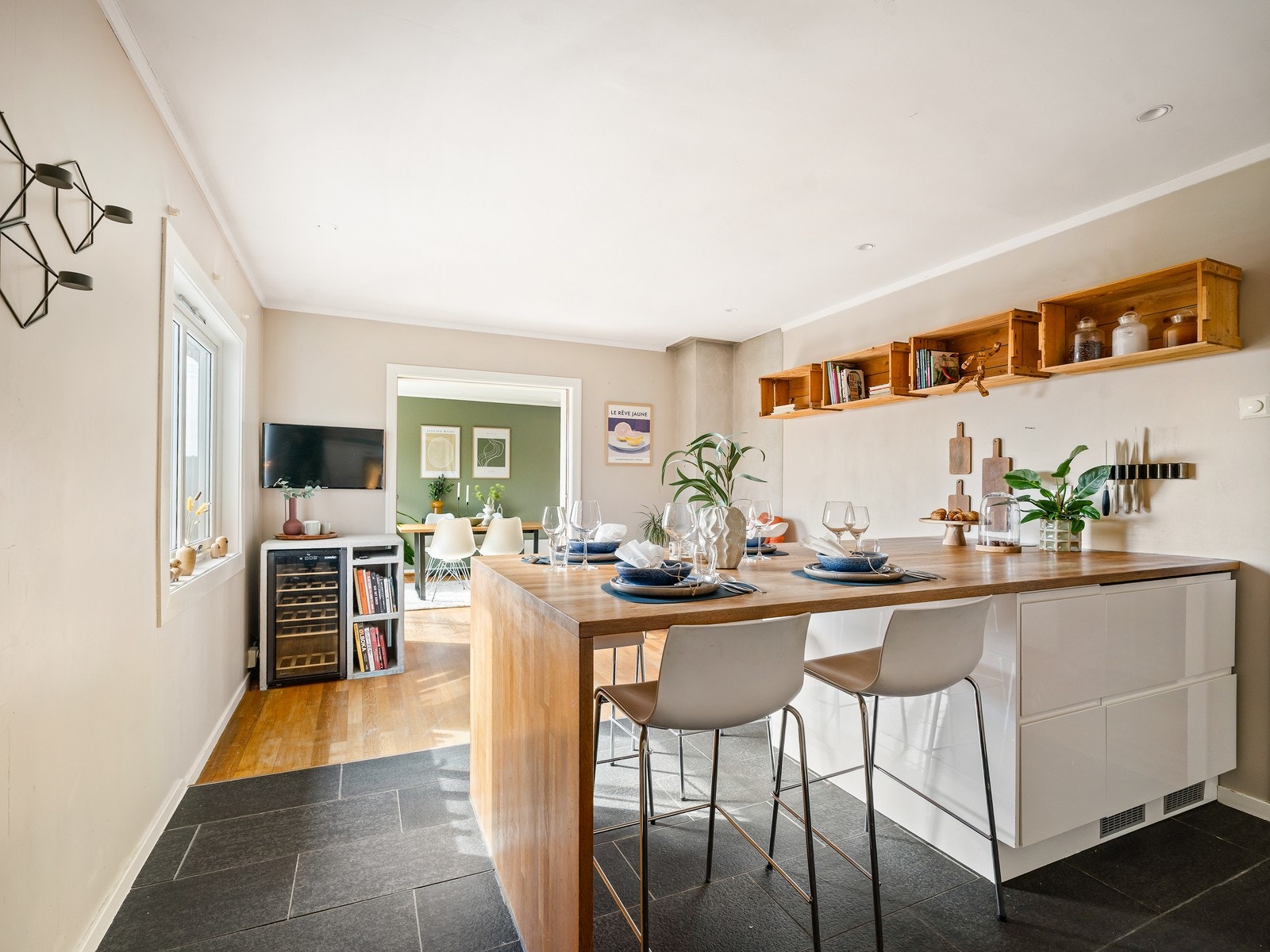 Kjøkkenøyen har godt med oppbevaringsplass i både skuffer og skap, og sitteplasser på begge sider av øya. Sitteplassene rundt kjøkkenøya skaper en innbydende og sosial sone, perfekt for å nyte morgenkaffen og en god frokost. Galleribilde