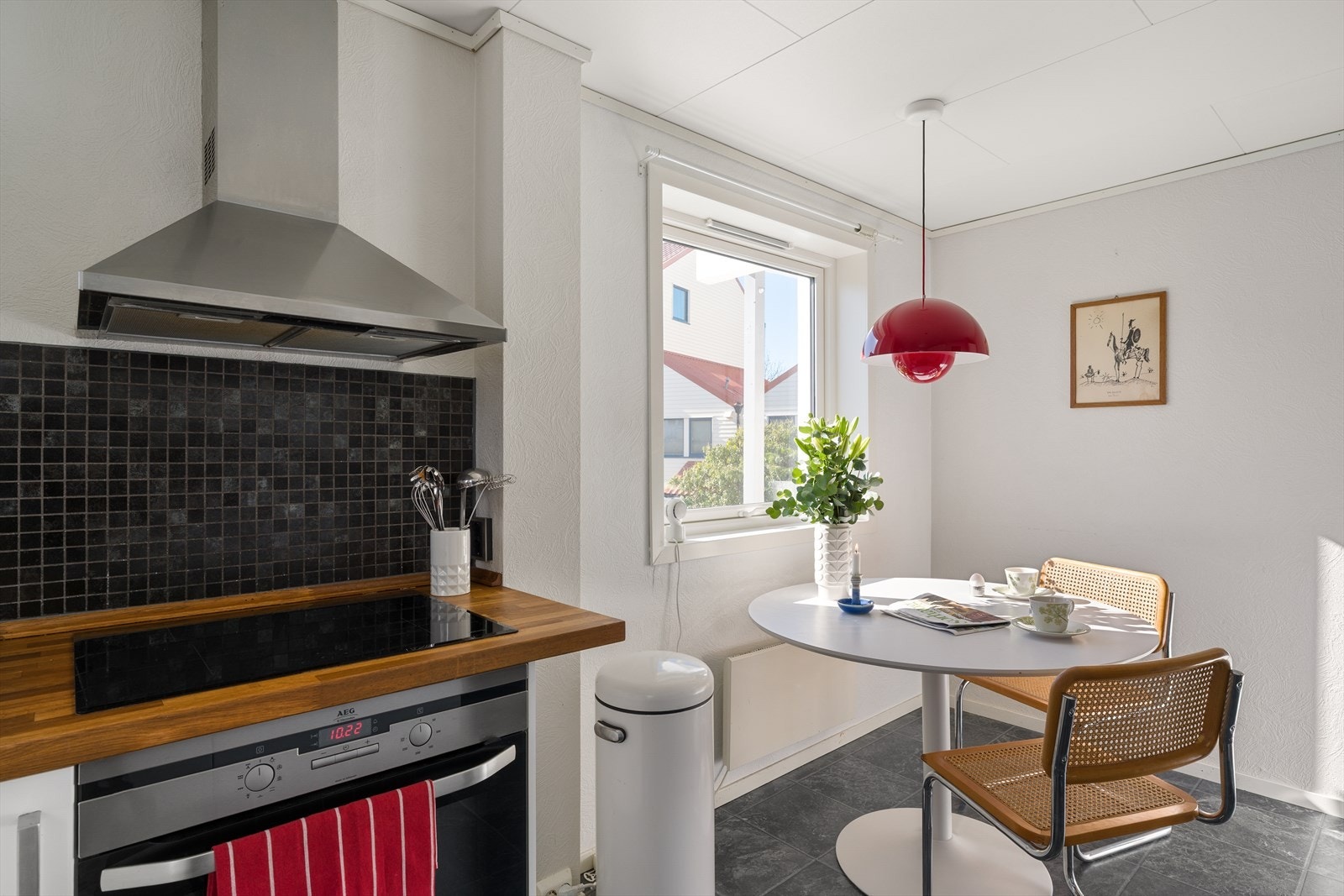 Det er laminatfliser på gulvet, malte plater med tapet på veggene og takess i taket. Det er flis som backsplash. Galleribilde