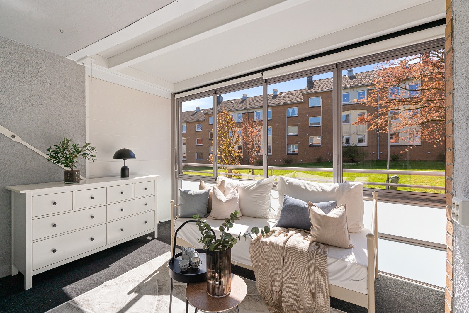Den sørvendte, innglassede balkongen inviterer til et lunt uterom med mange muligheter. Her kan du skape din egen oase med loungemøbler, grønne planter eller et spisebord - badet i sol og med en lun atmosfære store deler av året. Galleribilde