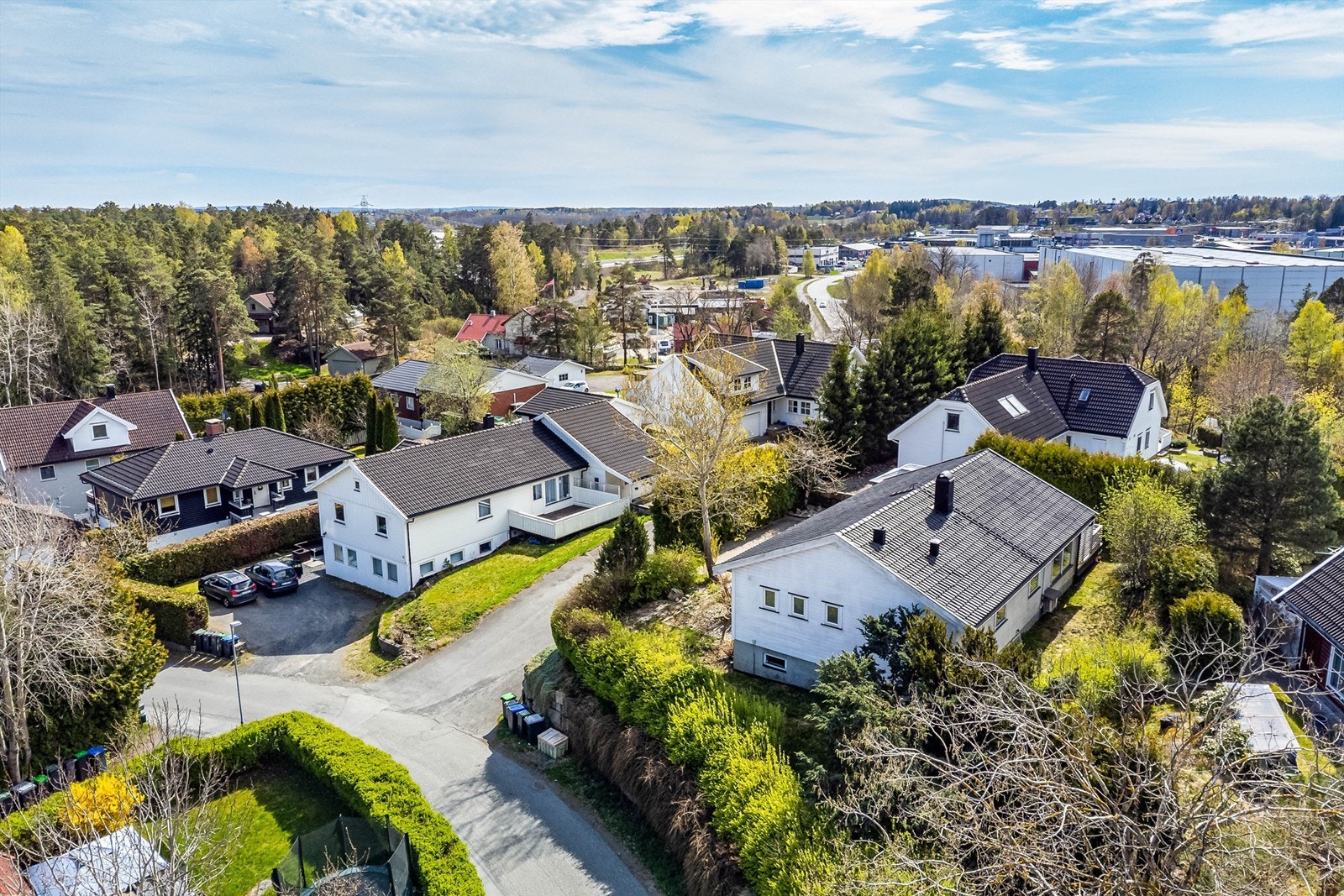 En lettstelt hage med gressplen er anlagt rundt boligens østre, nordre og vestre side - innrammet av tettvoksende hekker. Galleribilde