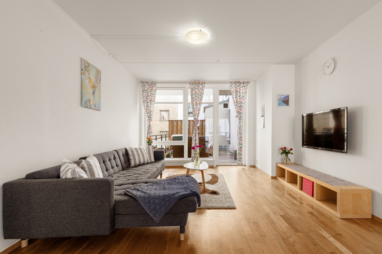 Rommet er fint inndelt i soner, med naturlig møblering for sofa- og spisegruppe Galleribilde