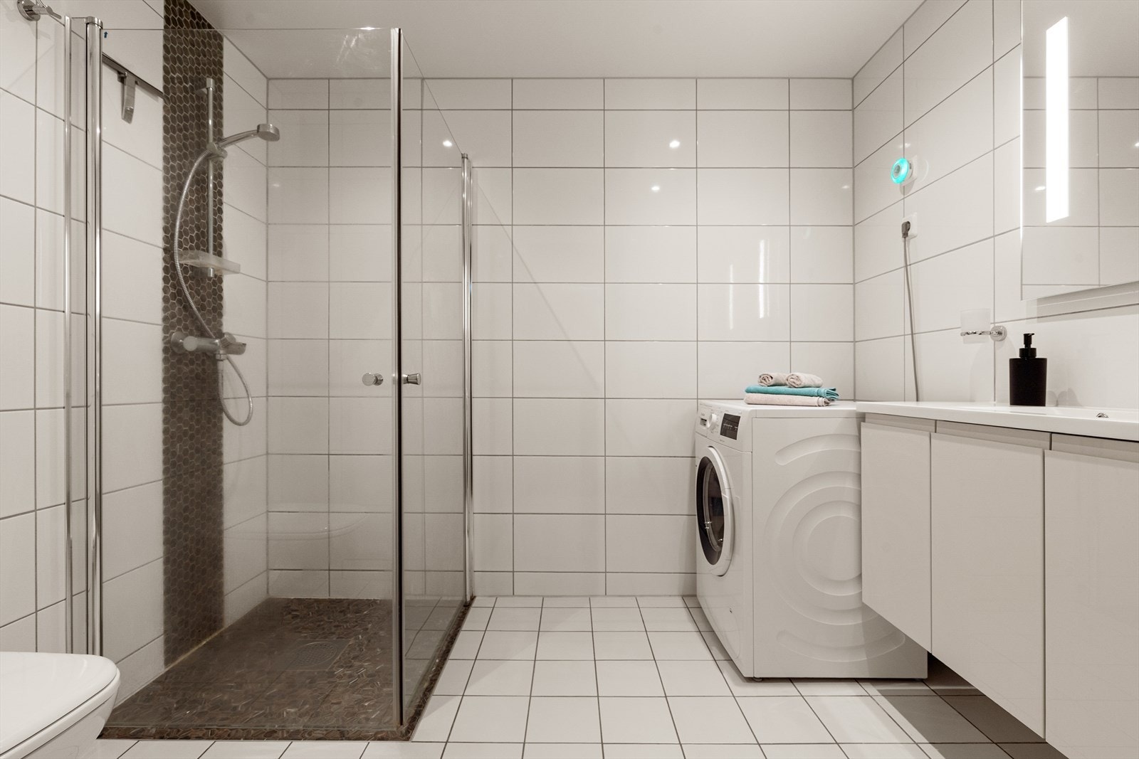 Leiligheten har et helfliset bad med downlights i tak og varme i gulv Galleribilde