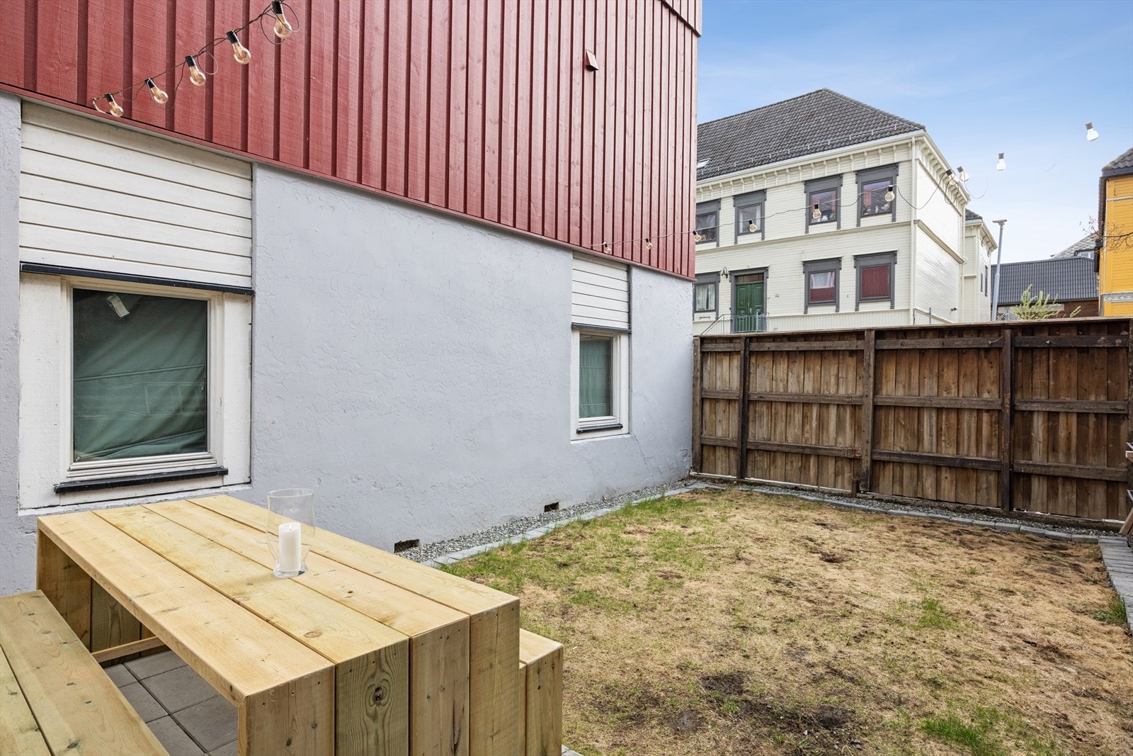 Skjermet bakgård med gressplen og utemøbler Galleribilde