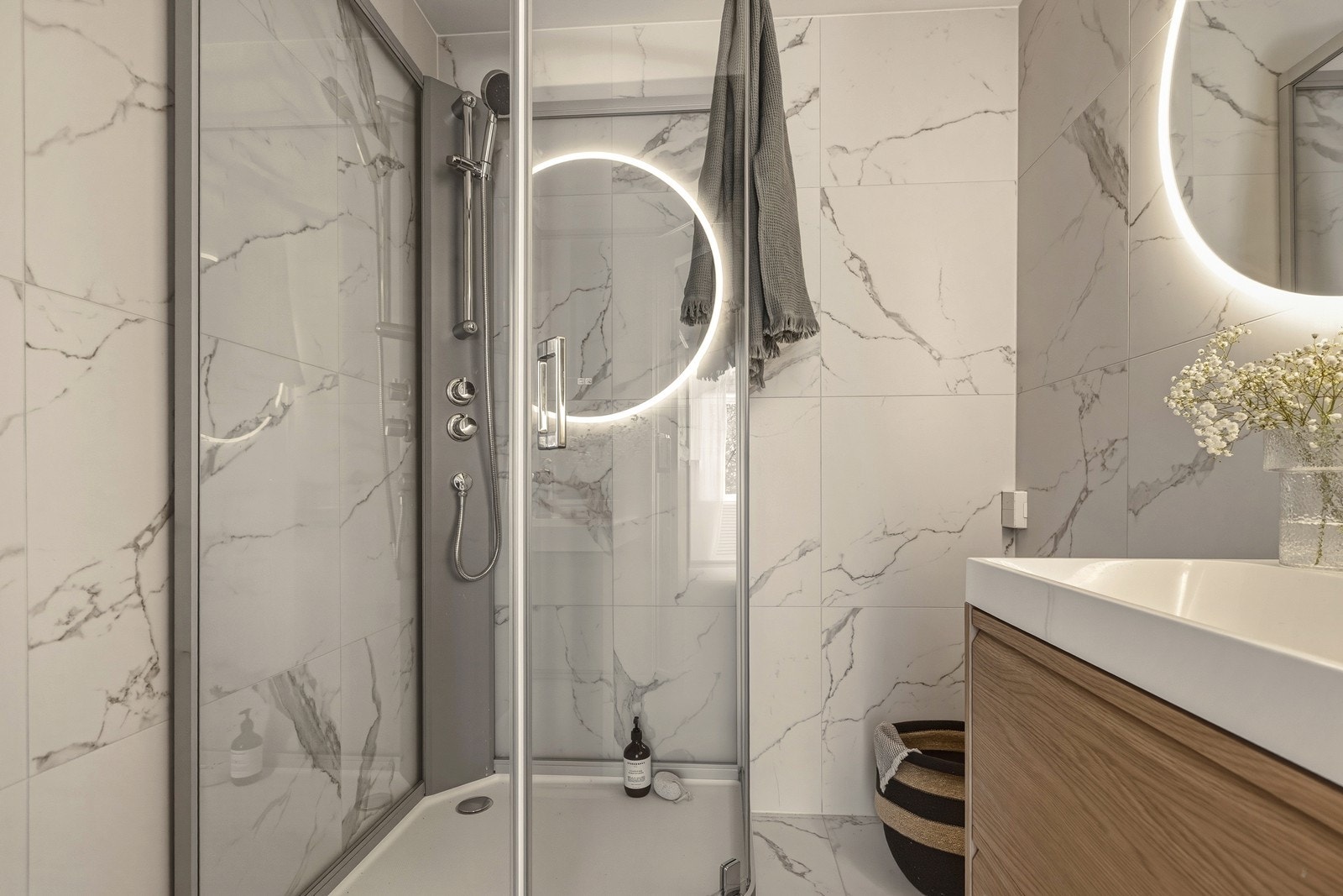 Lyst og fint bad med nye fliser og innredning fra 2026. Badet er innredet med nytt dusjkabinett og innredning med heldekkende servant og speil med lys. Galleribilde