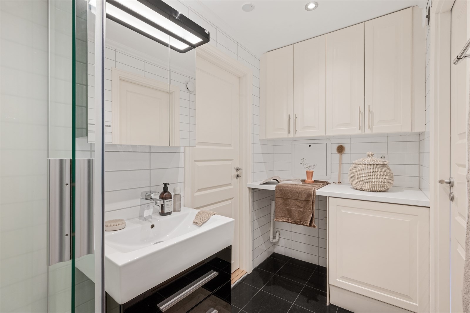 Badet er tidløst og stilrent. Samt svært praktisk med utgang til både soverom og entré. Galleribilde