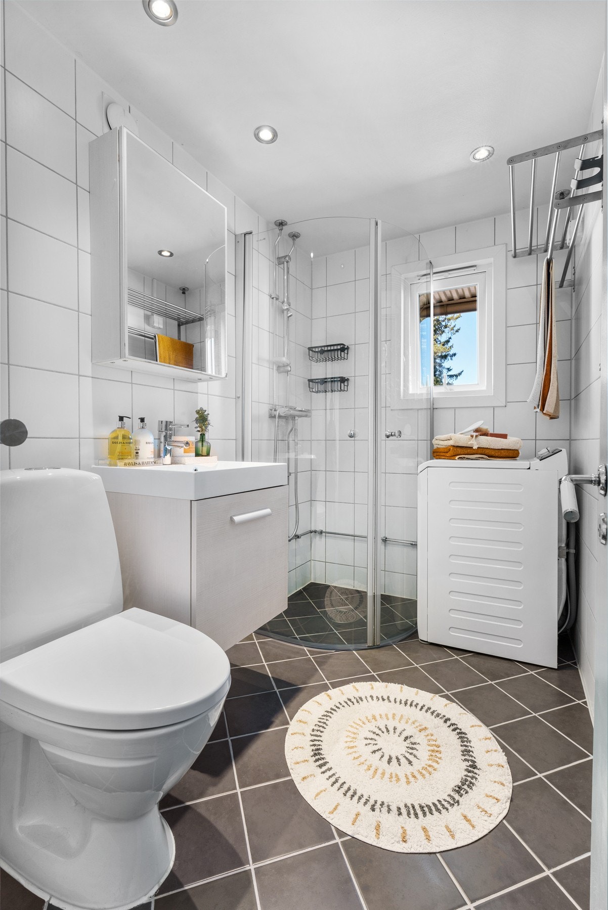 Badet ble rehabilitert i regi av borettslaget i 2008. Dusjsonen er adskilt med to skyvbare buede glassdører og det er opplegg for vaskemaskin. Galleribilde