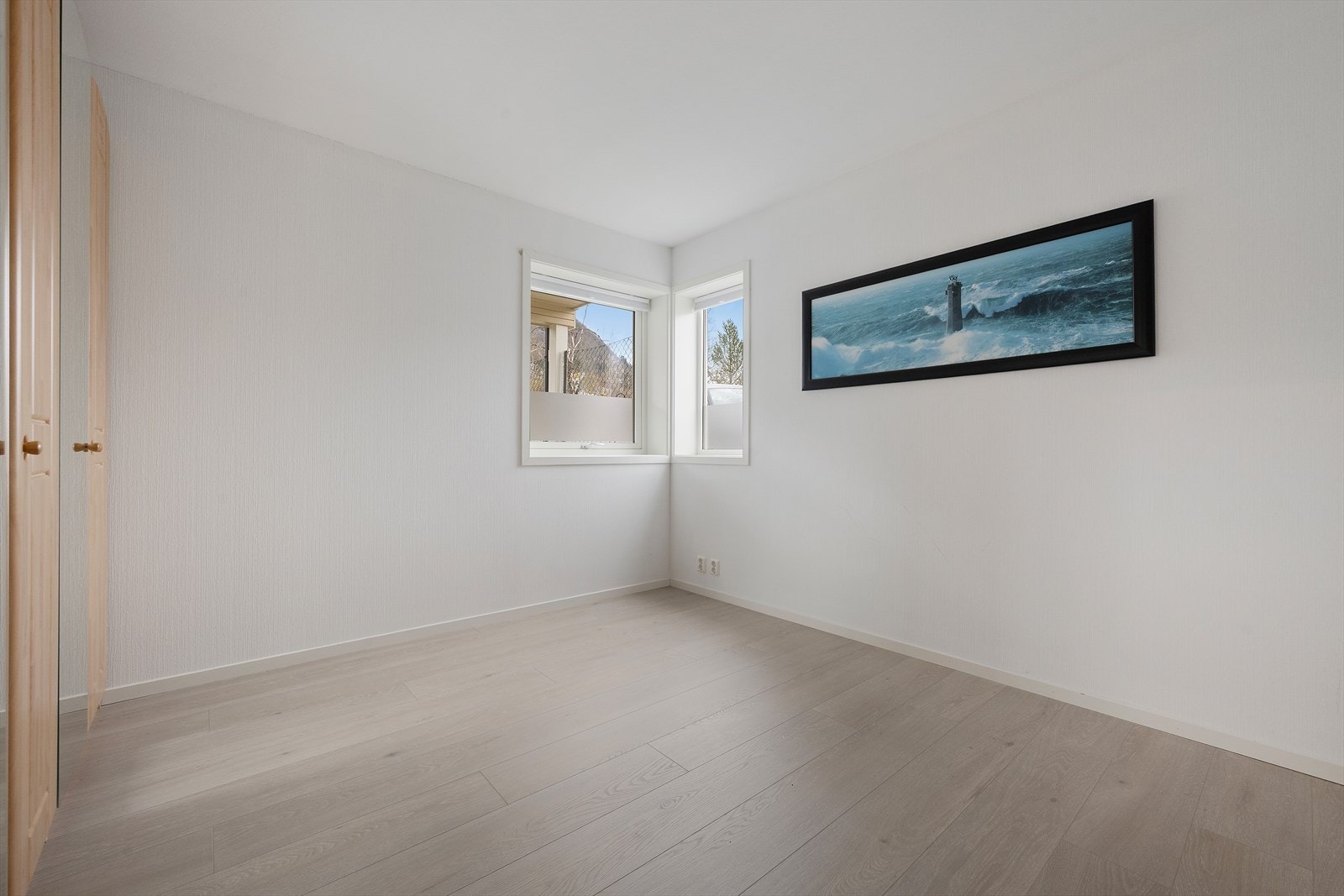 Soverom i første etasje med malte overflater og laminatgolv. Garderobeskap er fjerna. Galleribilde