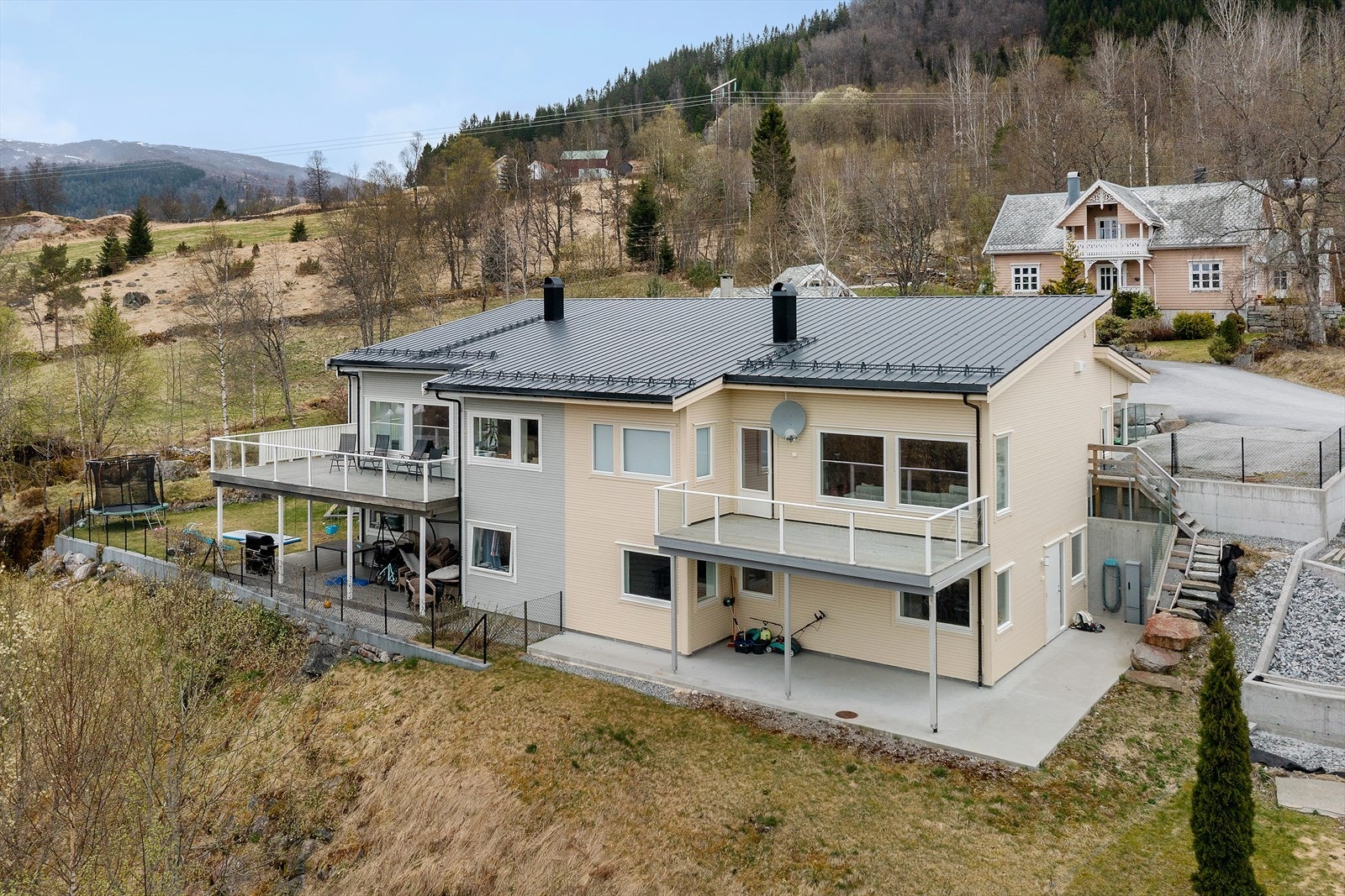Bustaden har uteplassar på begge plan. Ei sørvendt terrasse i første etasje og ein stor betongterrasse på bakkeplan. Galleribilde