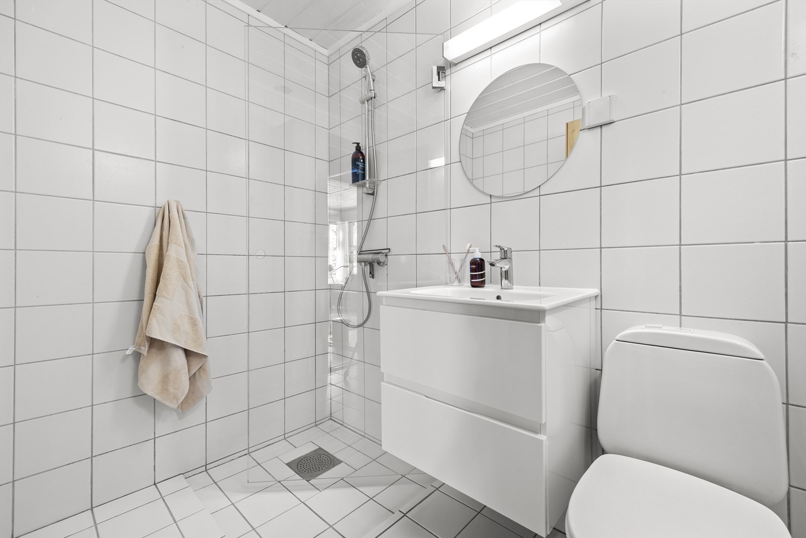 Underetasjen har to bad, begge fra opprinnelig byggeår. Rommet har flislagte overflater, mekanisk ventilasjon, servant på underskap, speil med belysning, klosett og dusj. Galleribilde