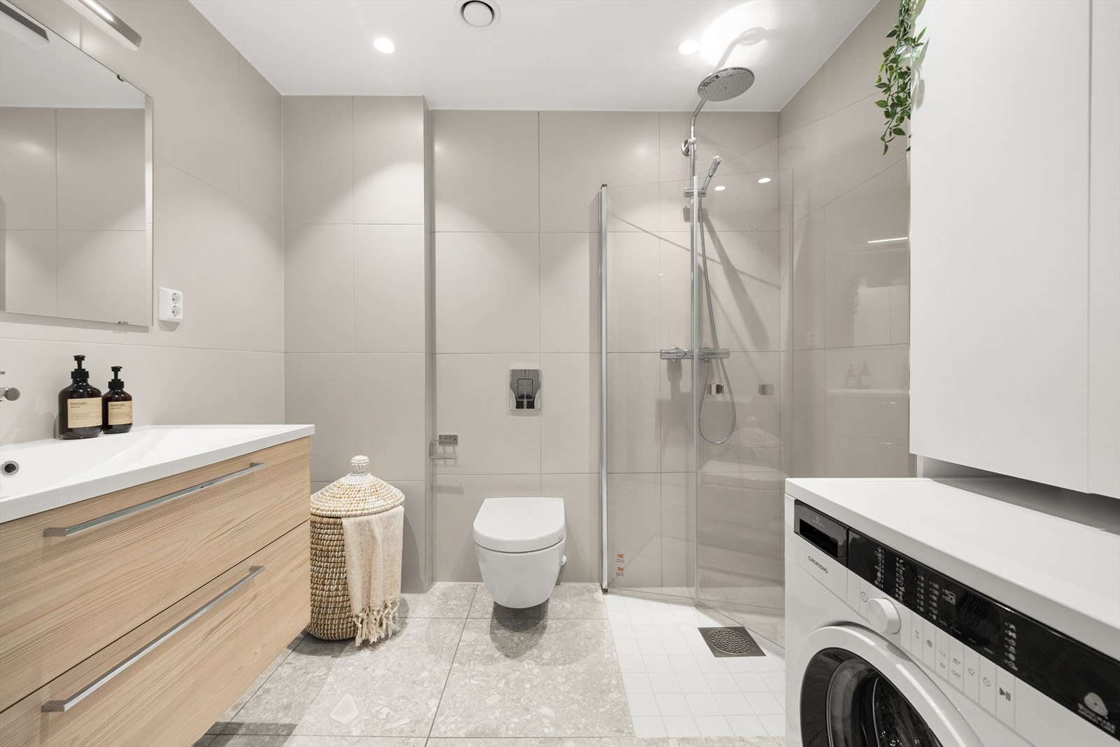 Badet er utstyrt med heldekkende servant med underskap, speil med lys, dusjnisje og toalett Galleribilde