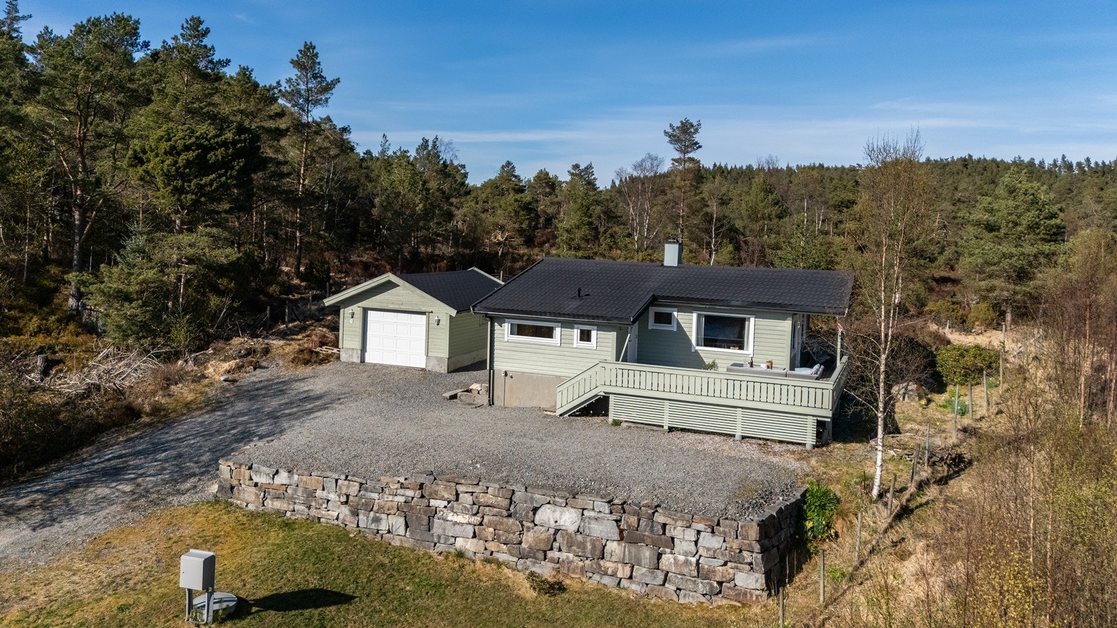 Stor gårdsplass og flott steinmur som rammer inn øverste platå av tomten. Galleribilde