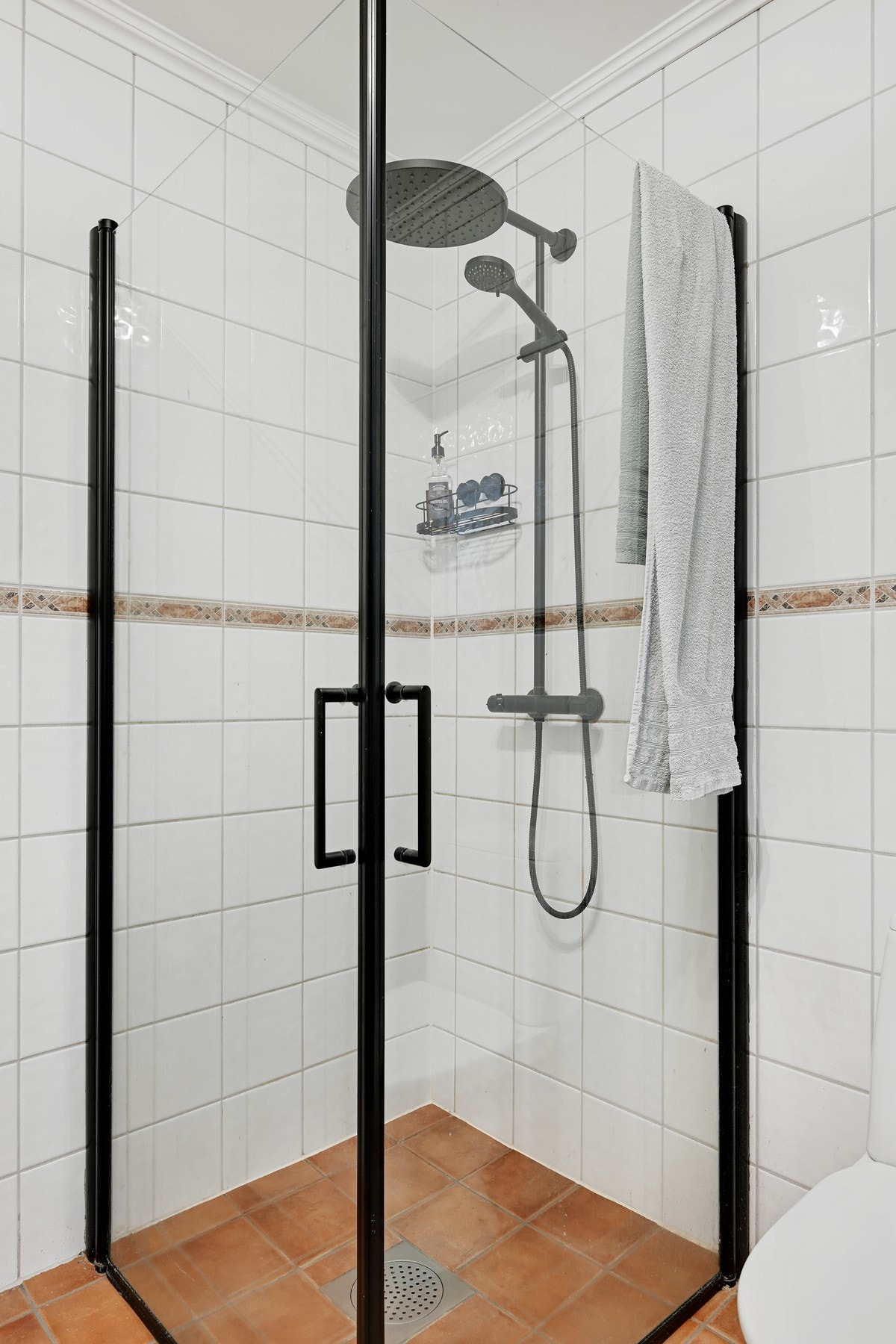 Badet inneholder dusjhjørne, servant med innredning og opplegg for vaskemaskin Galleribilde