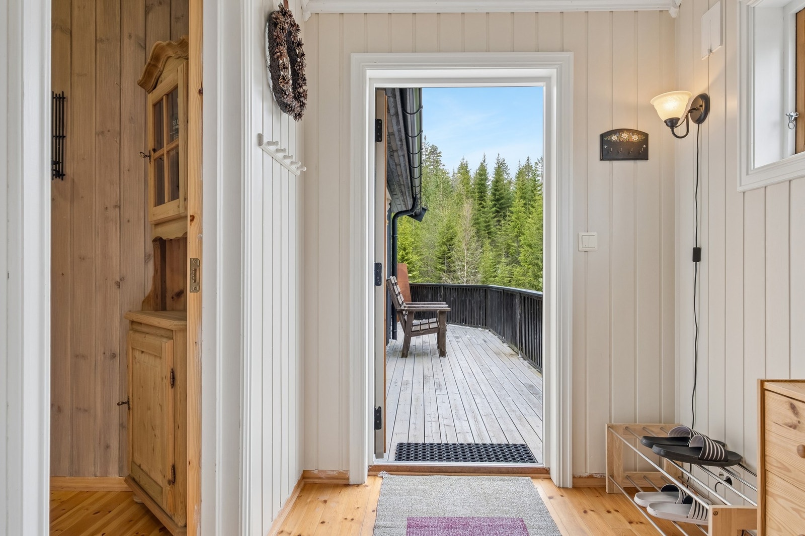 Lys gang med plass til å henge fra seg klær og sette sko. Galleribilde