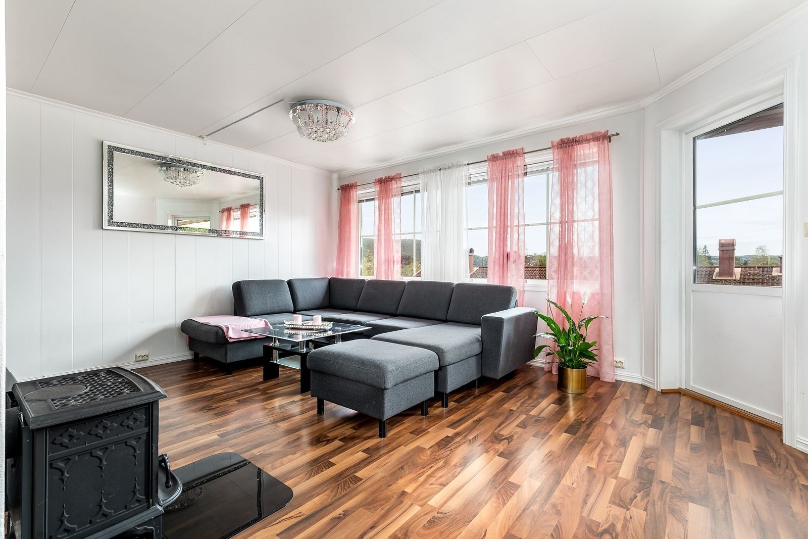 Romslig og lys stue med god plass til både sofa og tilhørende møblement Galleribilde