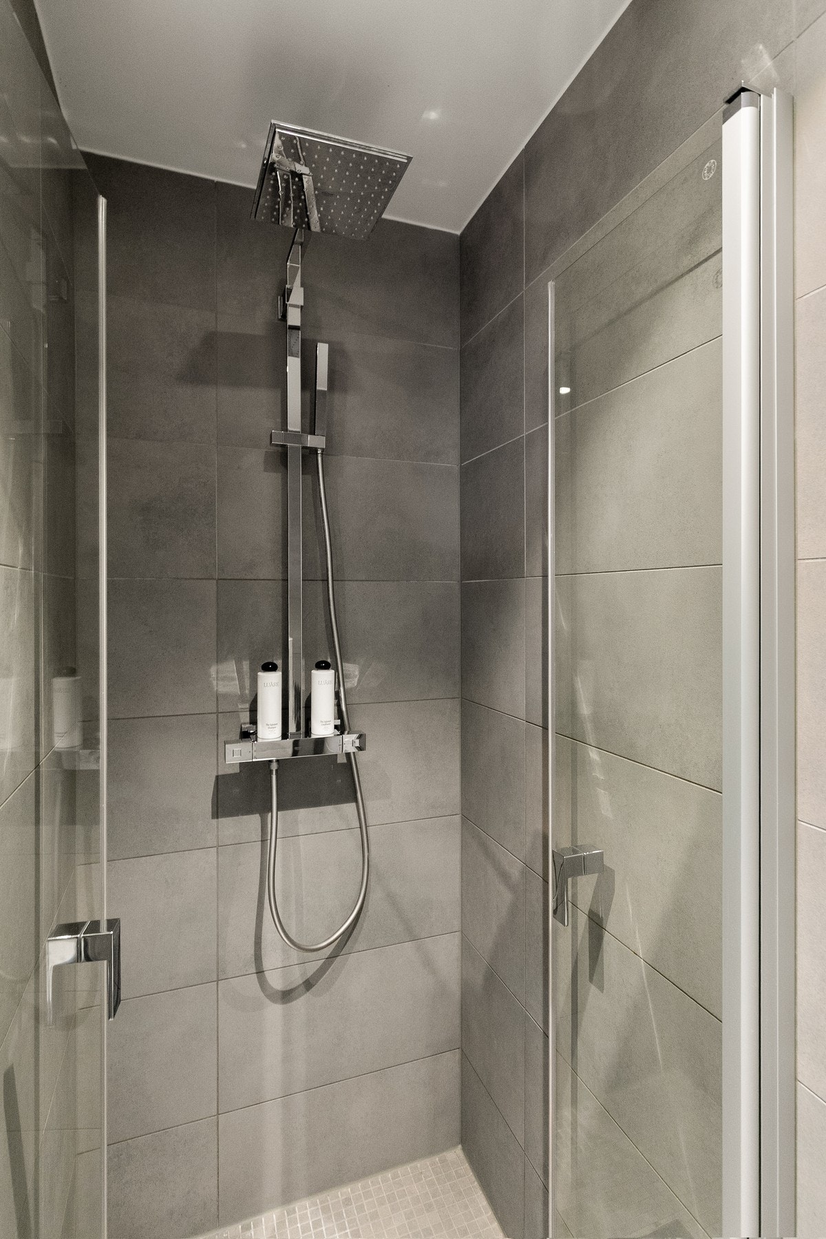 Badet er innredet med servant med underskap, speil, vegghengt toalett samt en praktisk dusjnisje. Galleribilde
