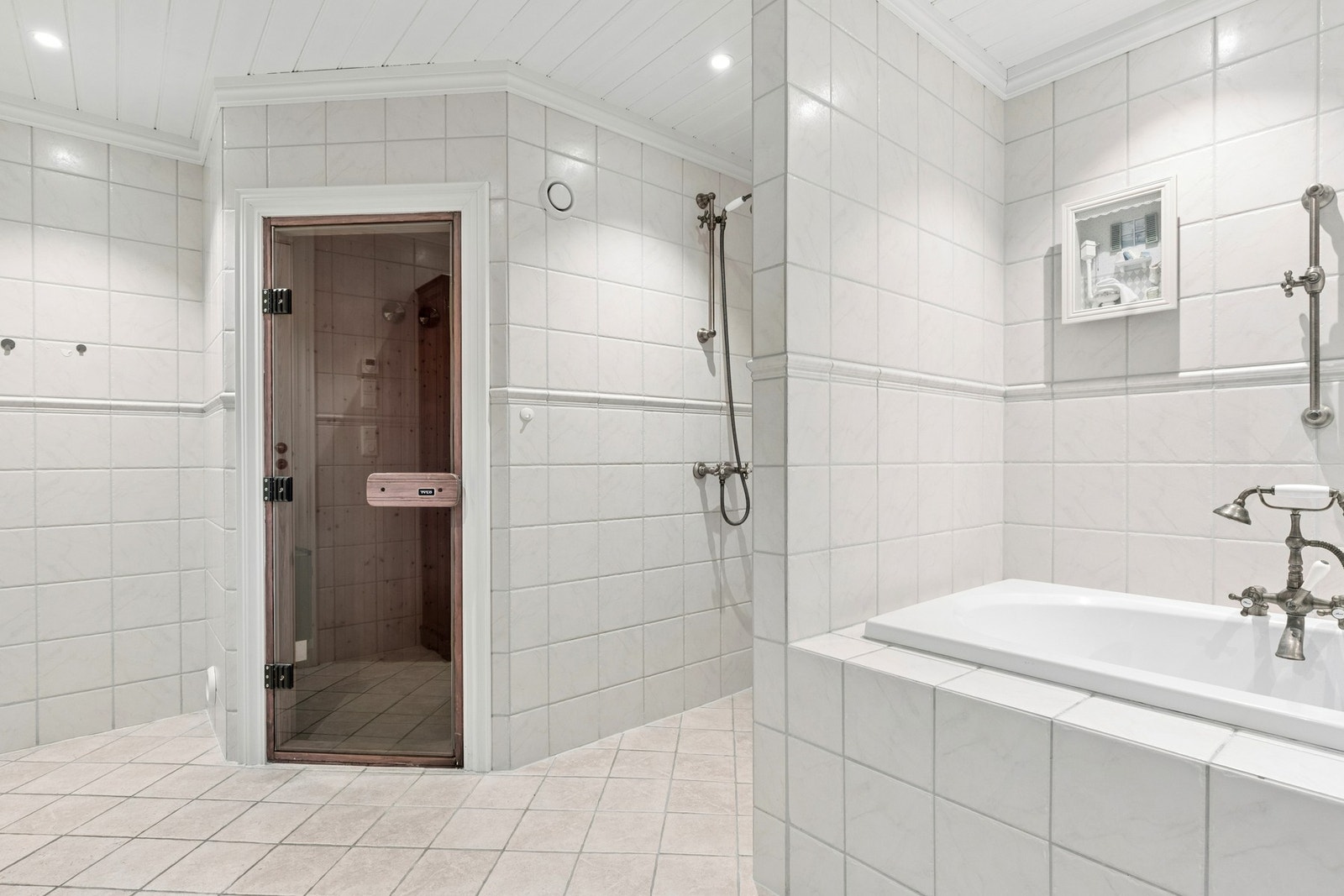 Badet er utstyrt med dusjløsning, badekar og servantinnredning. Galleribilde