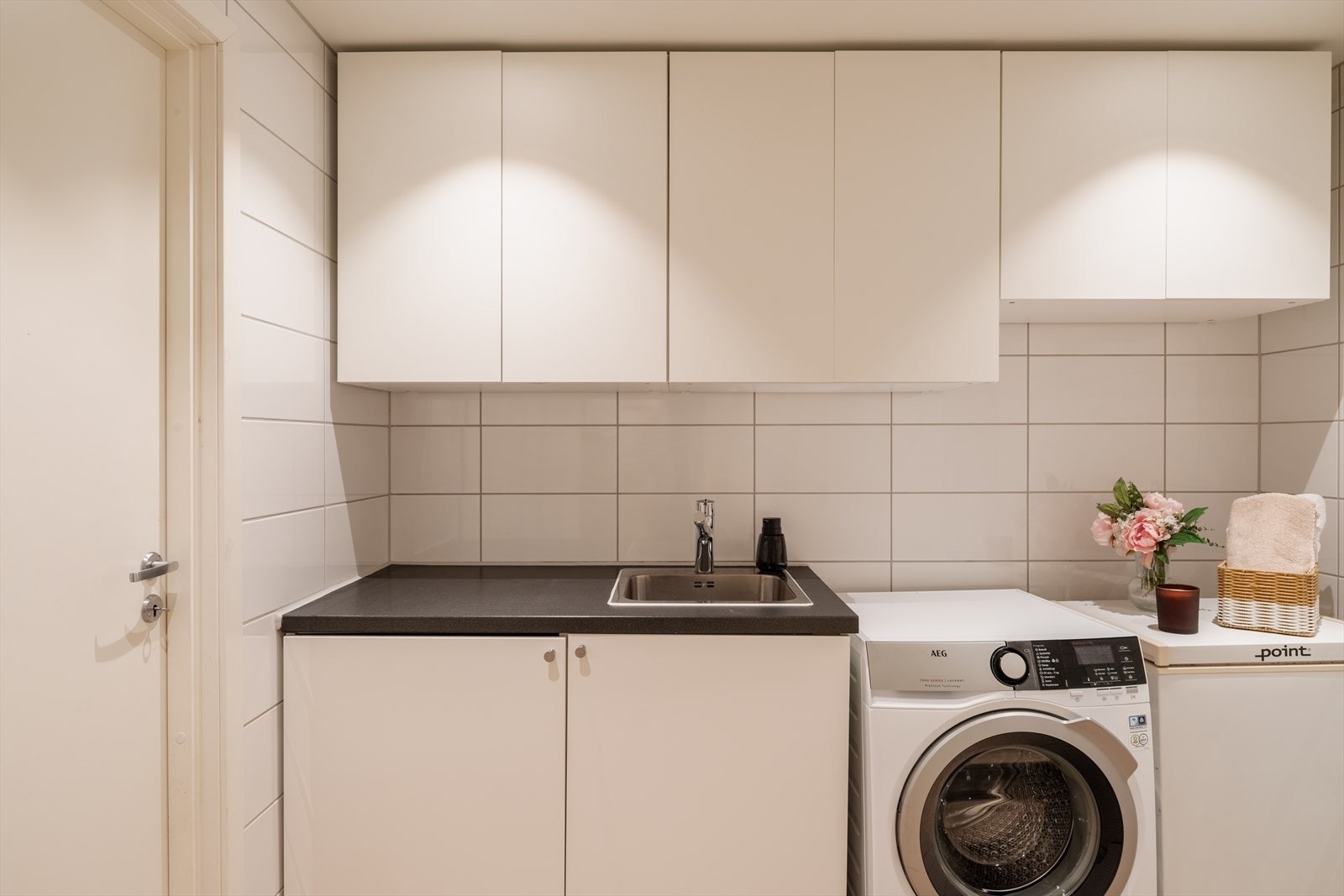 Her har du fiks ferdig opplegg for både vaskemaskin og tørketrommel, samt en dyp vaskekum og god skapplass til vaskemidler. Galleribilde