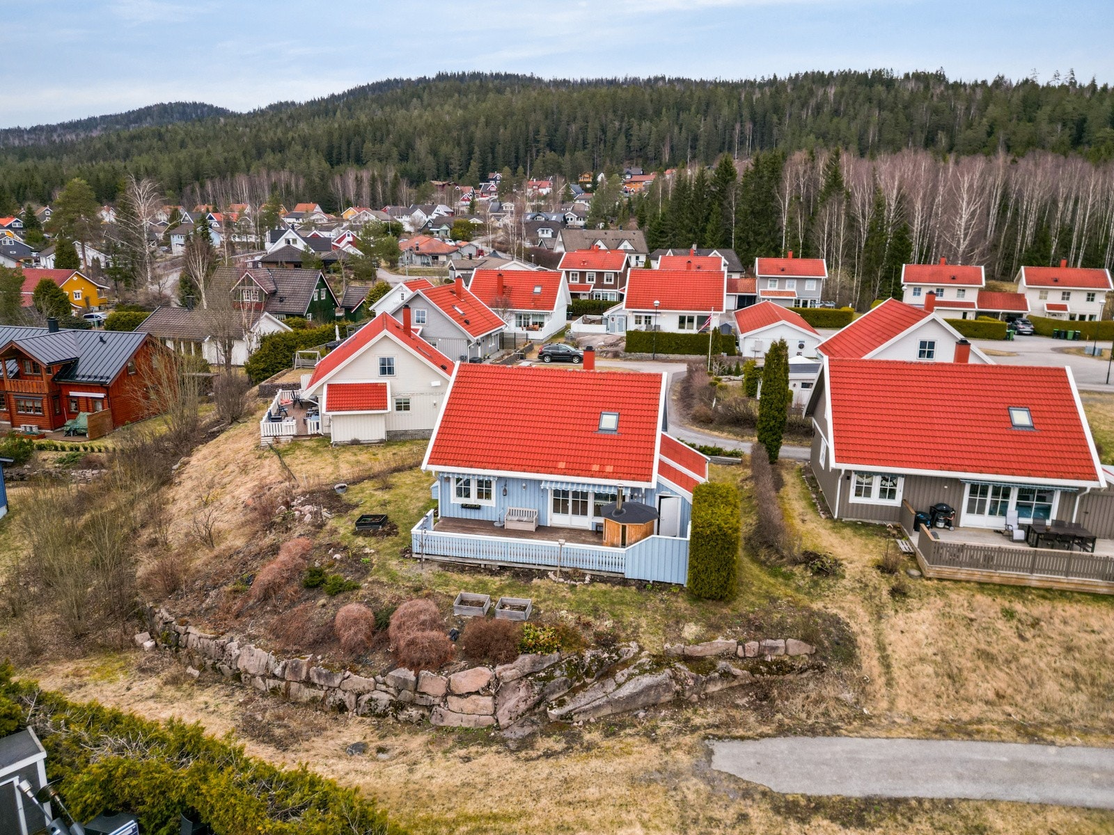 Eiendommen ligger fint til i terrenget, med en opparbeidet tomt som inkluderer plen og steinlagte arealer. Galleribilde