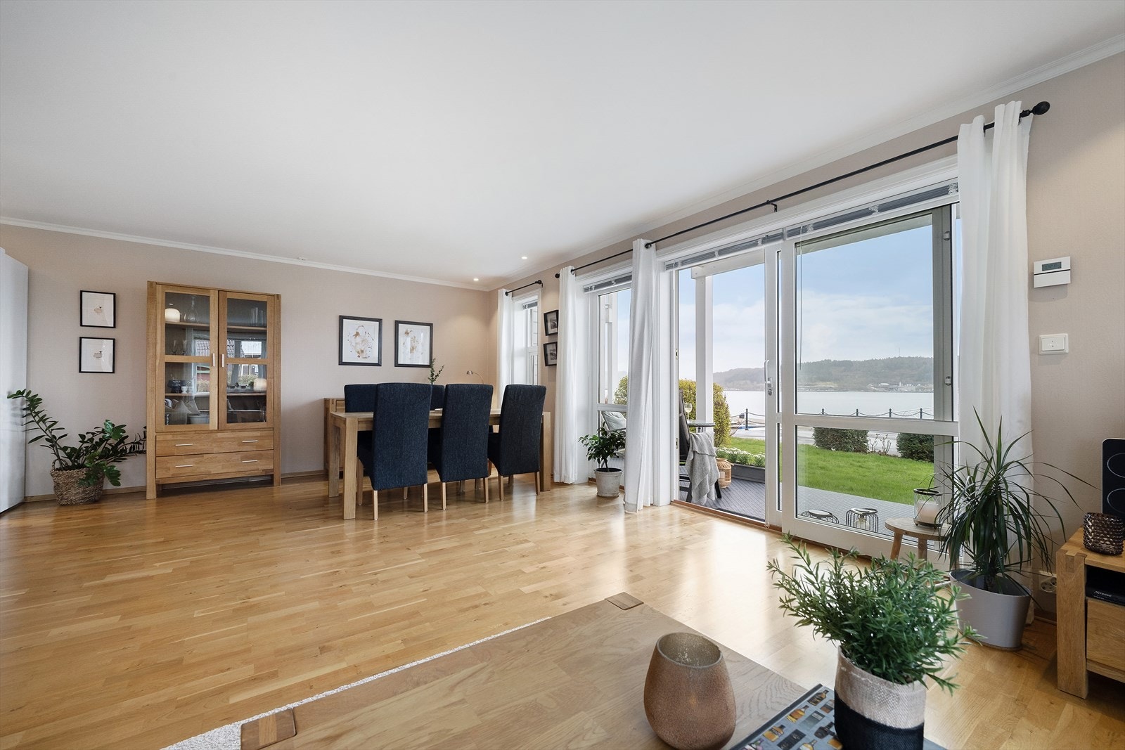 Stova har god plass til både sofagruppe og spisebord, med store vindaugsflater som vender ut mot sjøen. Galleribilde