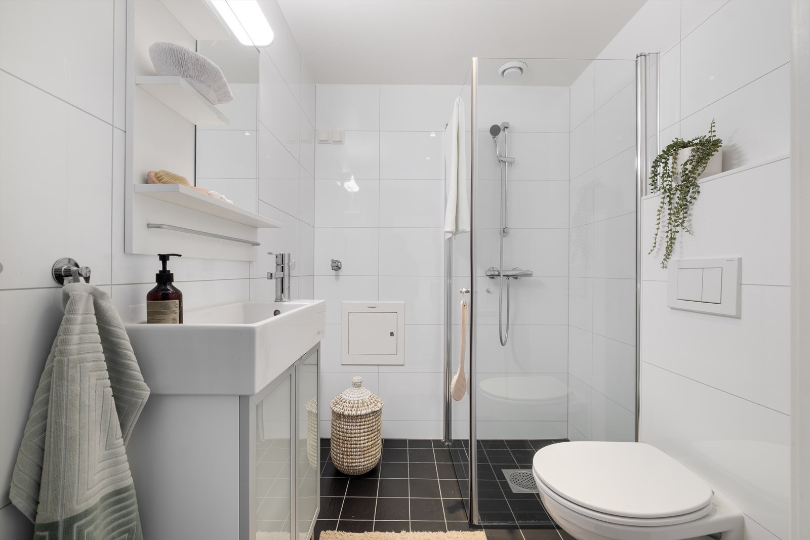 Romslig flislagt bad med varmekabler, avtrekk, downlights og opplegg for vaksemaskin. Galleribilde