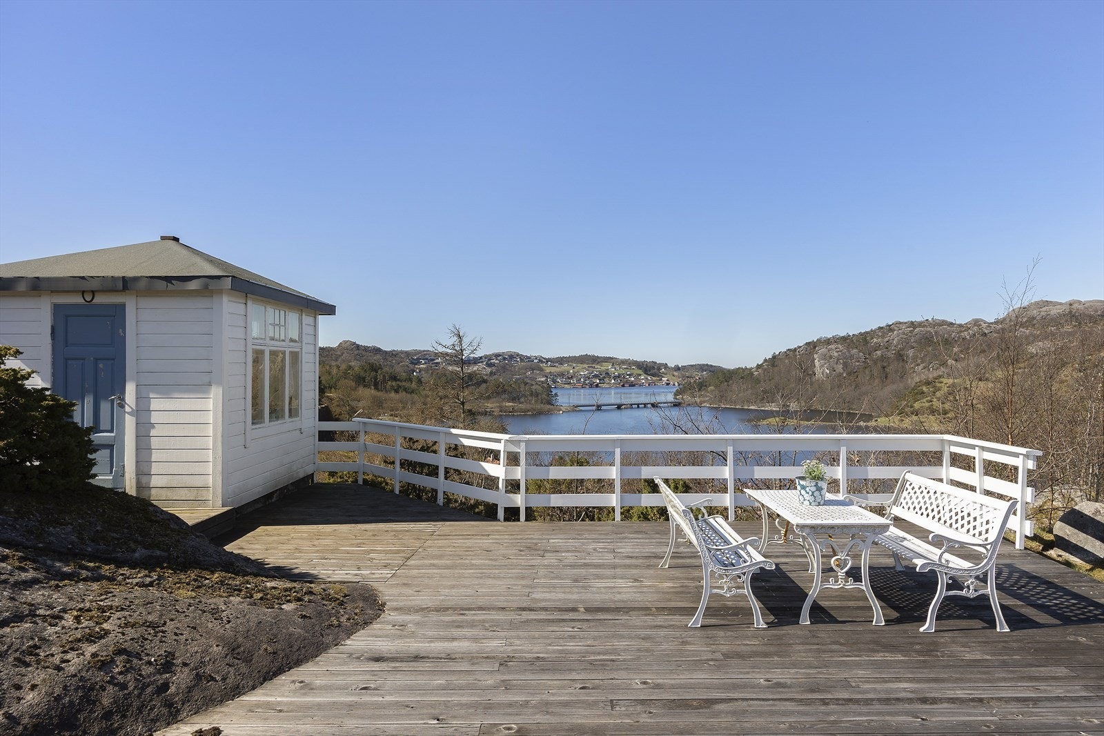 Lysthuset har en tilhørende terrasse med utsikt over vannet. Galleribilde