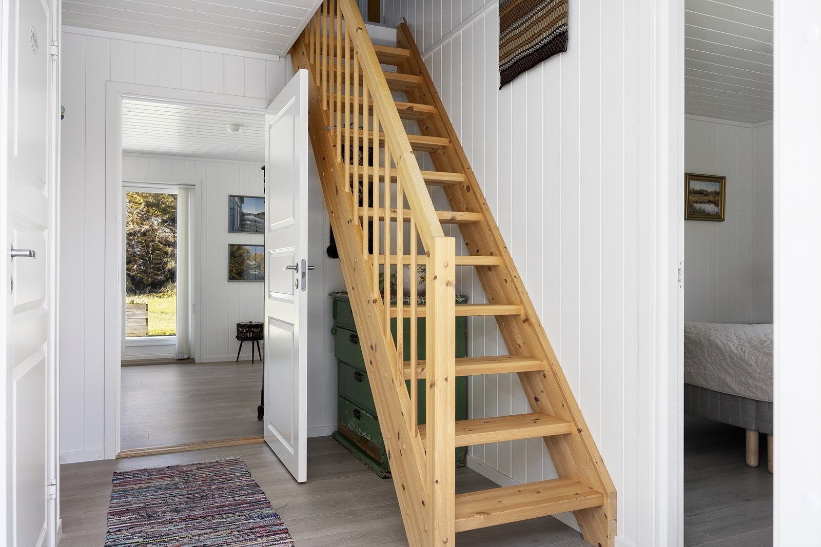 Entréen ønsker velkommen med gjennomgående laminatgulv og trapp i furu opp til hemsen. Galleribilde