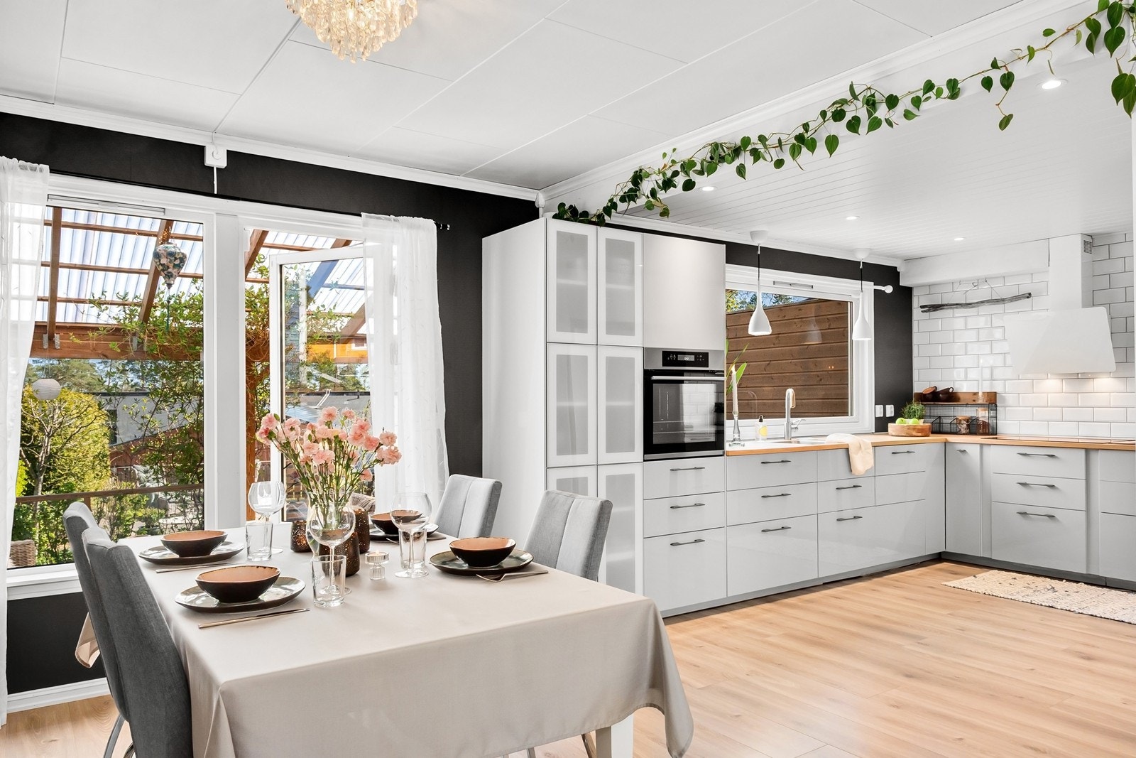 Herfra er det utgang til en romslig terrasse med overbygg og videre tilgang til grønn hage. Galleribilde