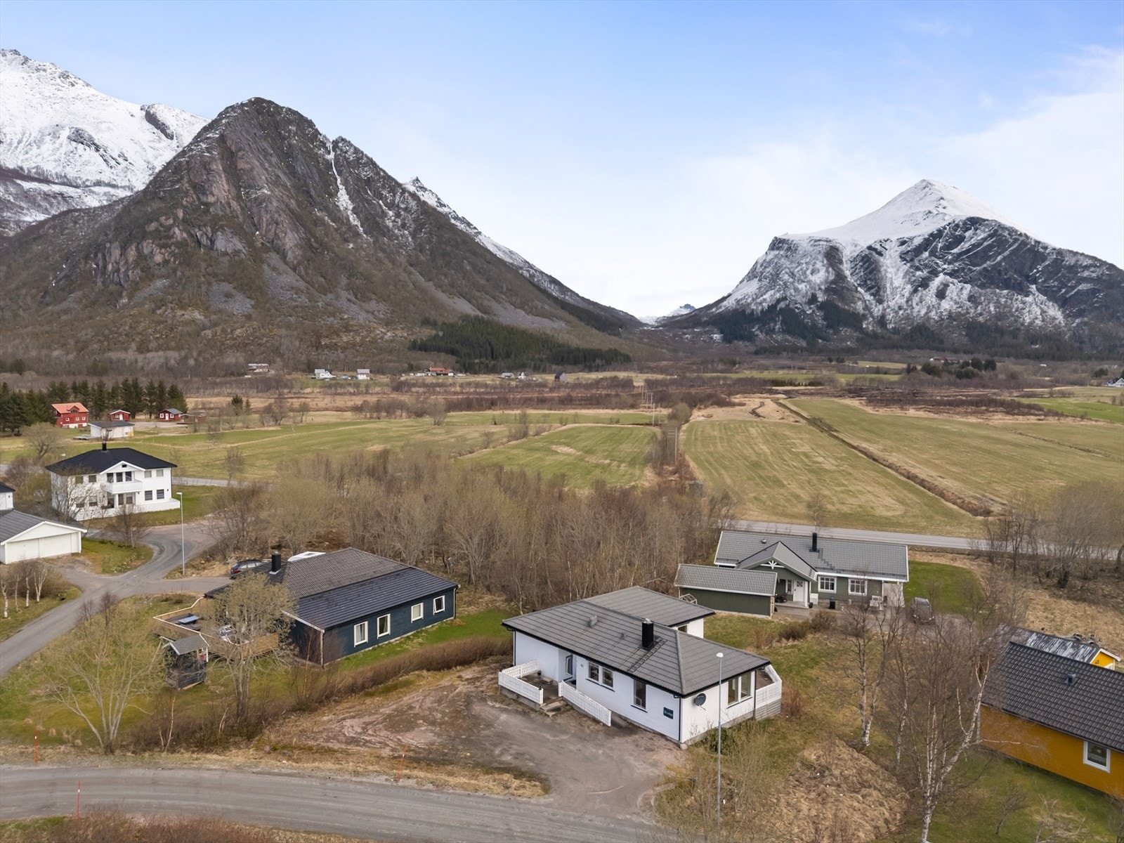 Tomten på 1 mål bestående gruset innkjørsel, plen og diverse prydebusker. Galleribilde