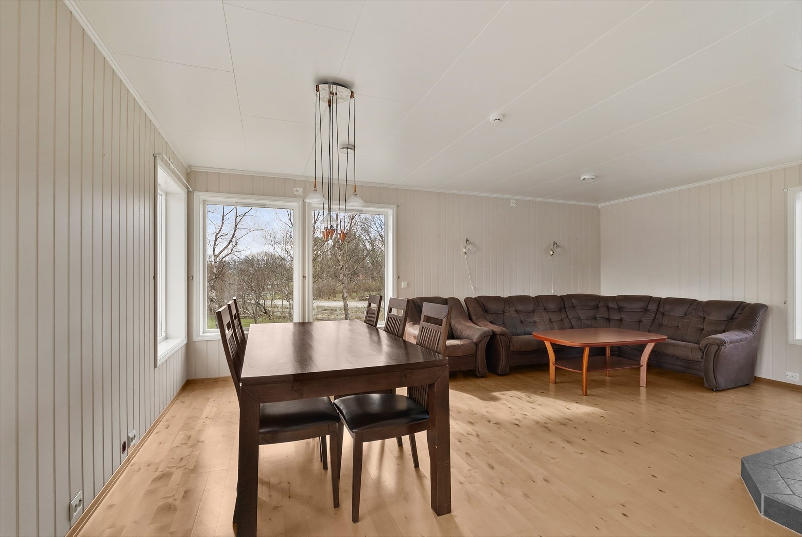 Romslig og lys stue med naturlige soner for både sofa og spisebord. Galleribilde