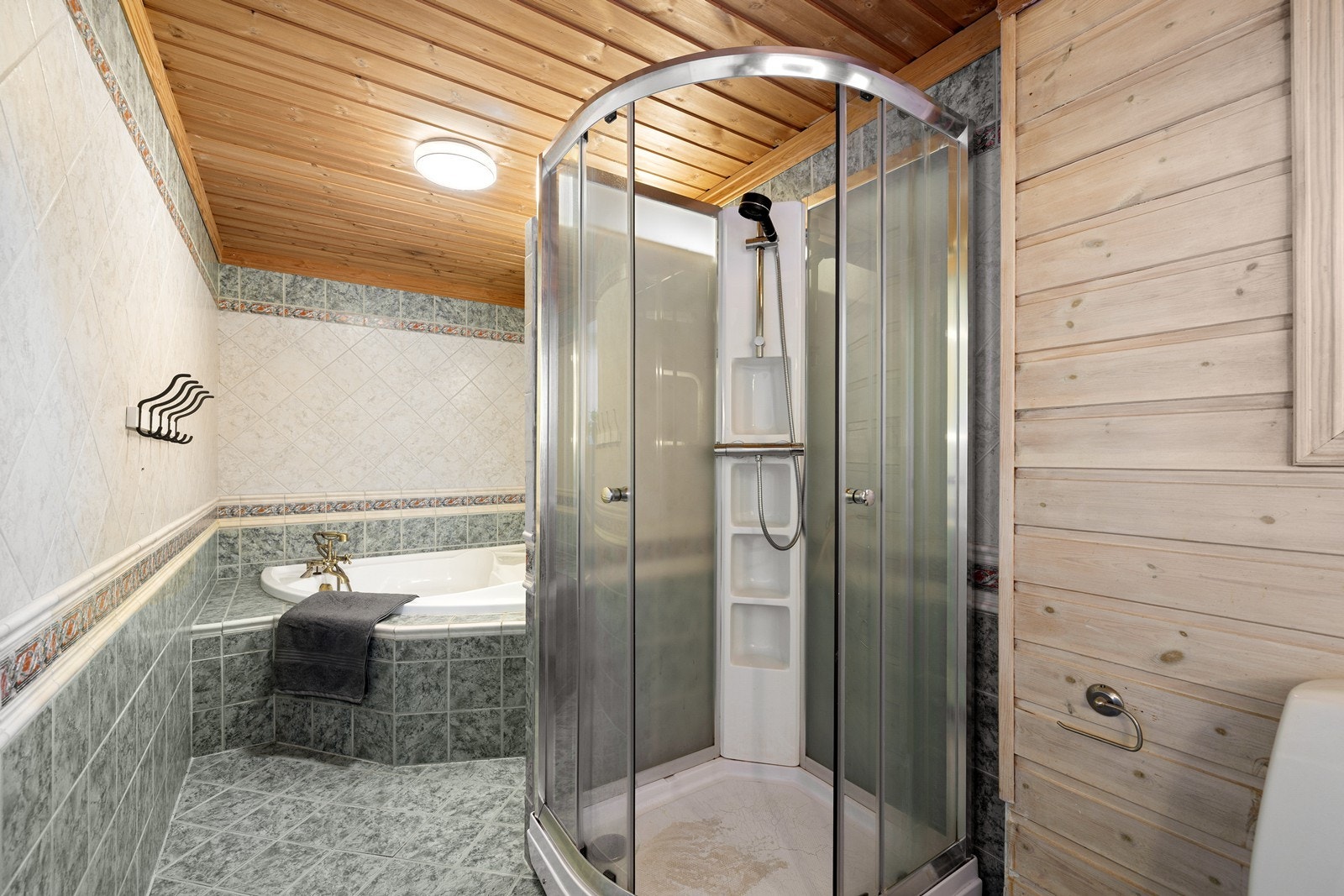 Badet er videre utstyrt med utstyrt med toalett, samt både dusjkabinett og et innebygget badekar. Galleribilde