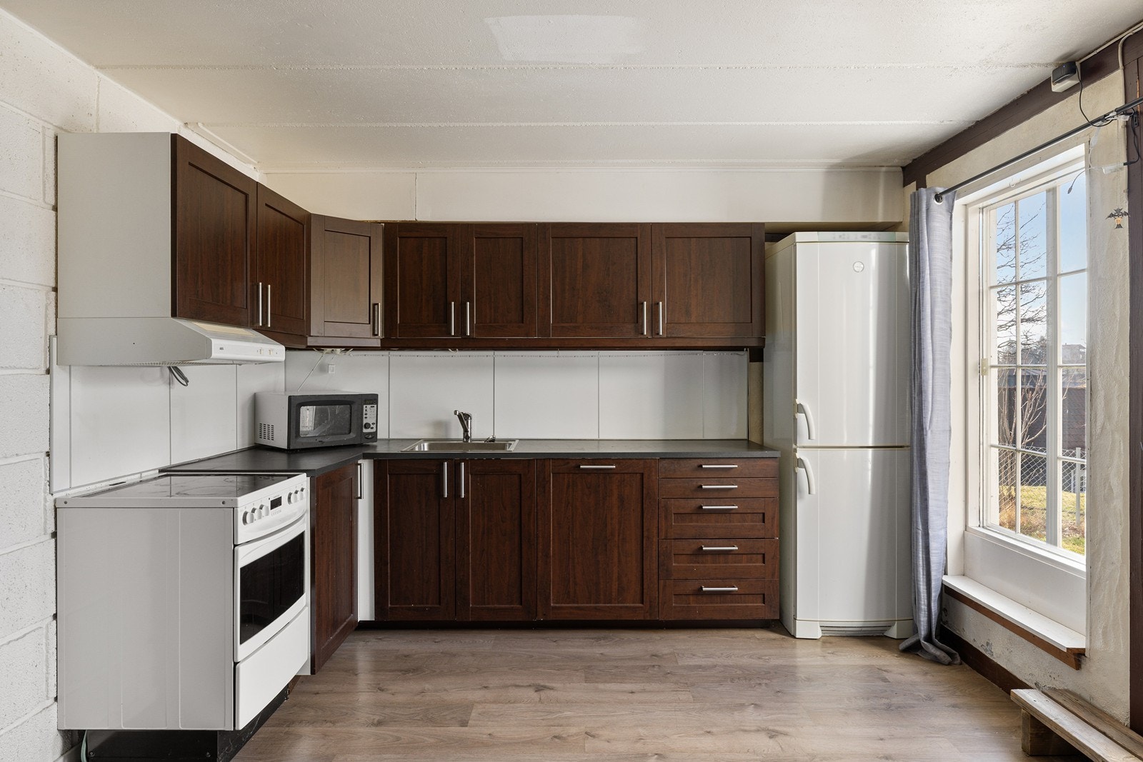 Kjøkkeninnredningen fra 2016 har profilerte fronter, moderne backsplash og opplegg for oppvaskmaskin. Galleribilde