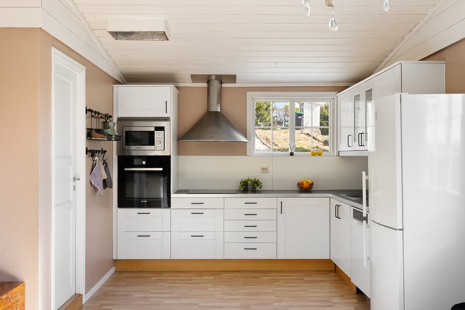 Kjøkkenet er funksjonelt utstyrt med integrerte hvitevarer, herunder induksjonstopp med tilhørende ventilator, stekeovn plassert i praktisk arbeidshøyde, mikrobølgeovn og oppvaskmaskin. Galleribilde