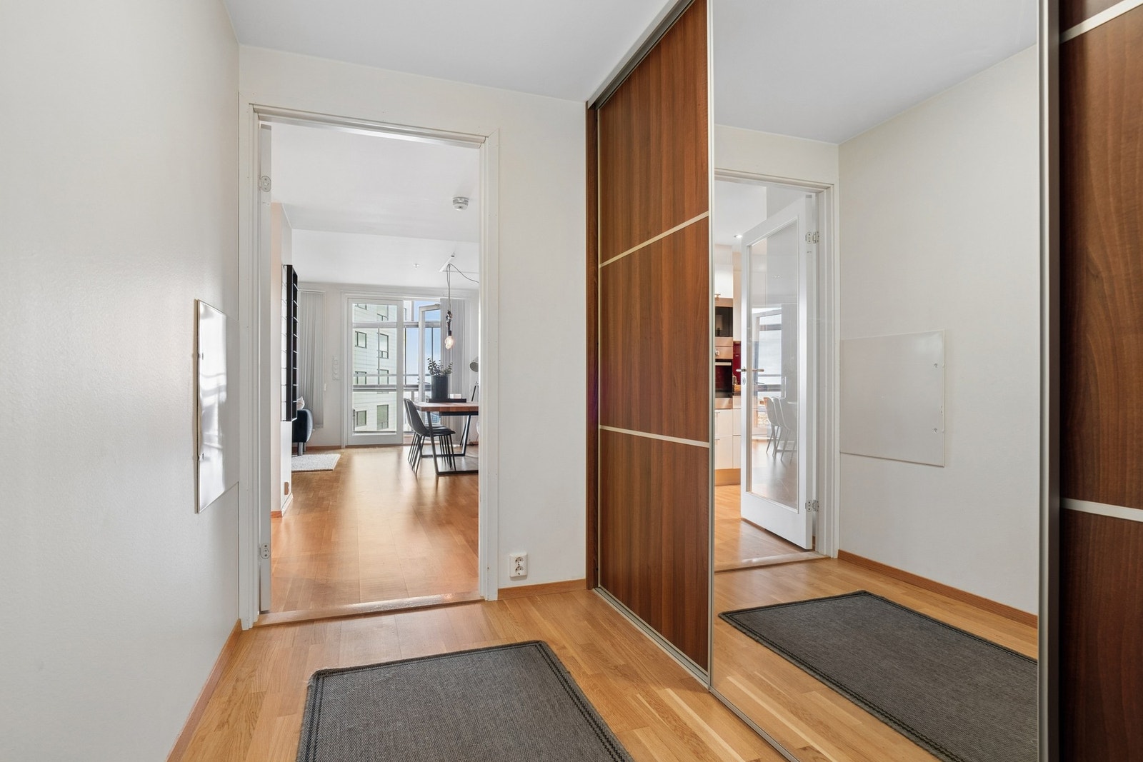 Romslig entré med en stor skyvedørsgarderobe for effektiv oppbevaring av yttertøy og sko. Galleribilde