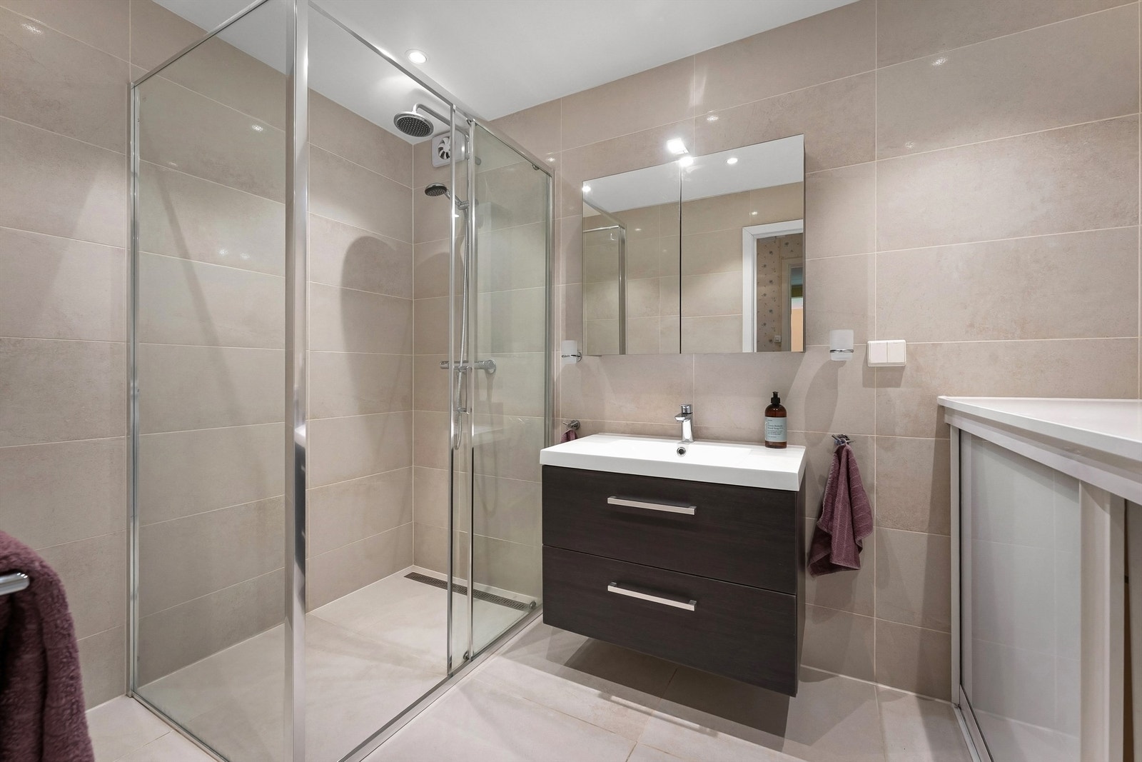 Badet i første etasje er flislagt og utstyrt med gulvvarme, downlights og dusjhjørne med regndusj. Galleribilde