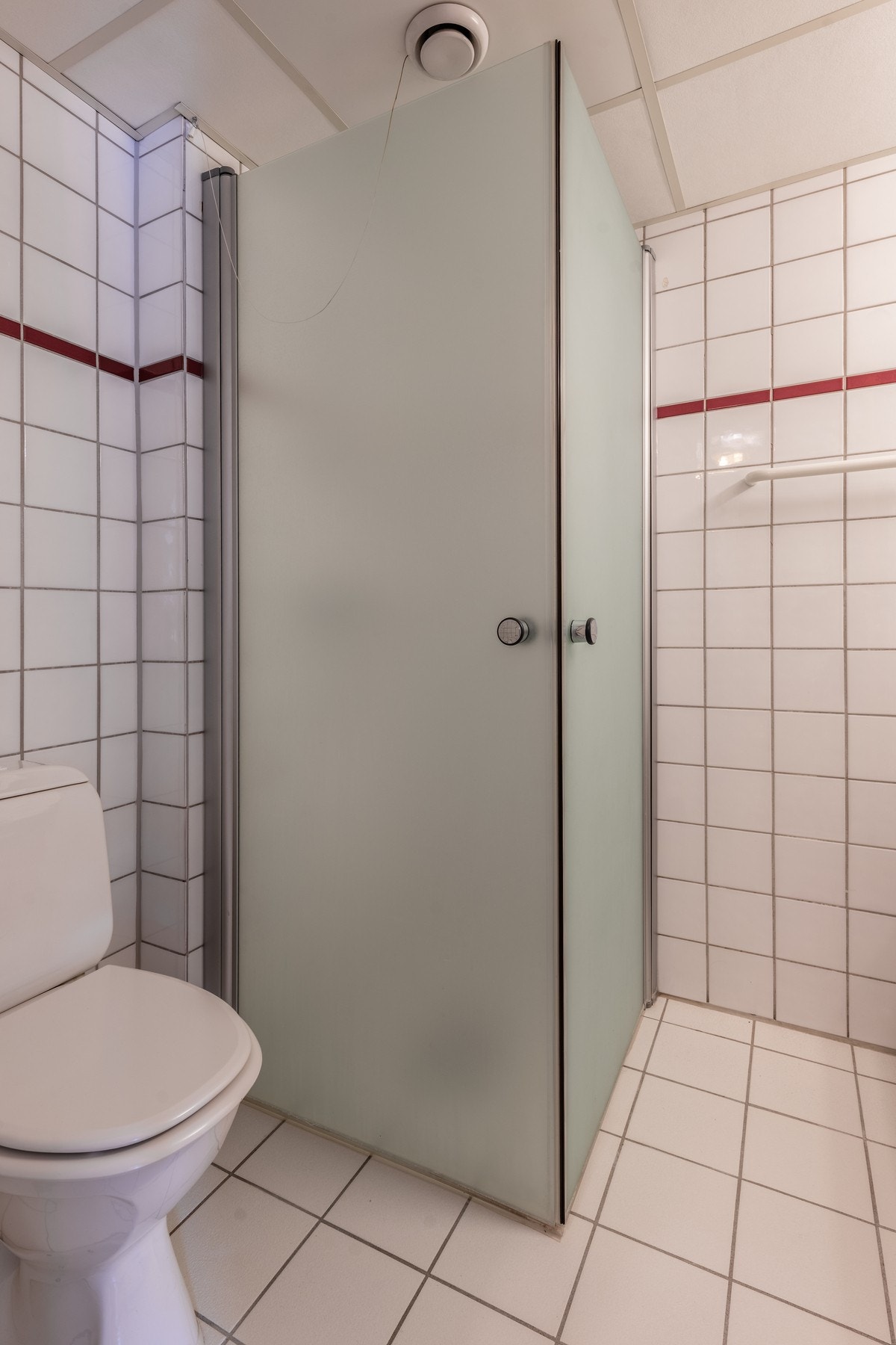 Badet i studiodelen har hvite fliser og varmekabler i gulvet. Galleribilde