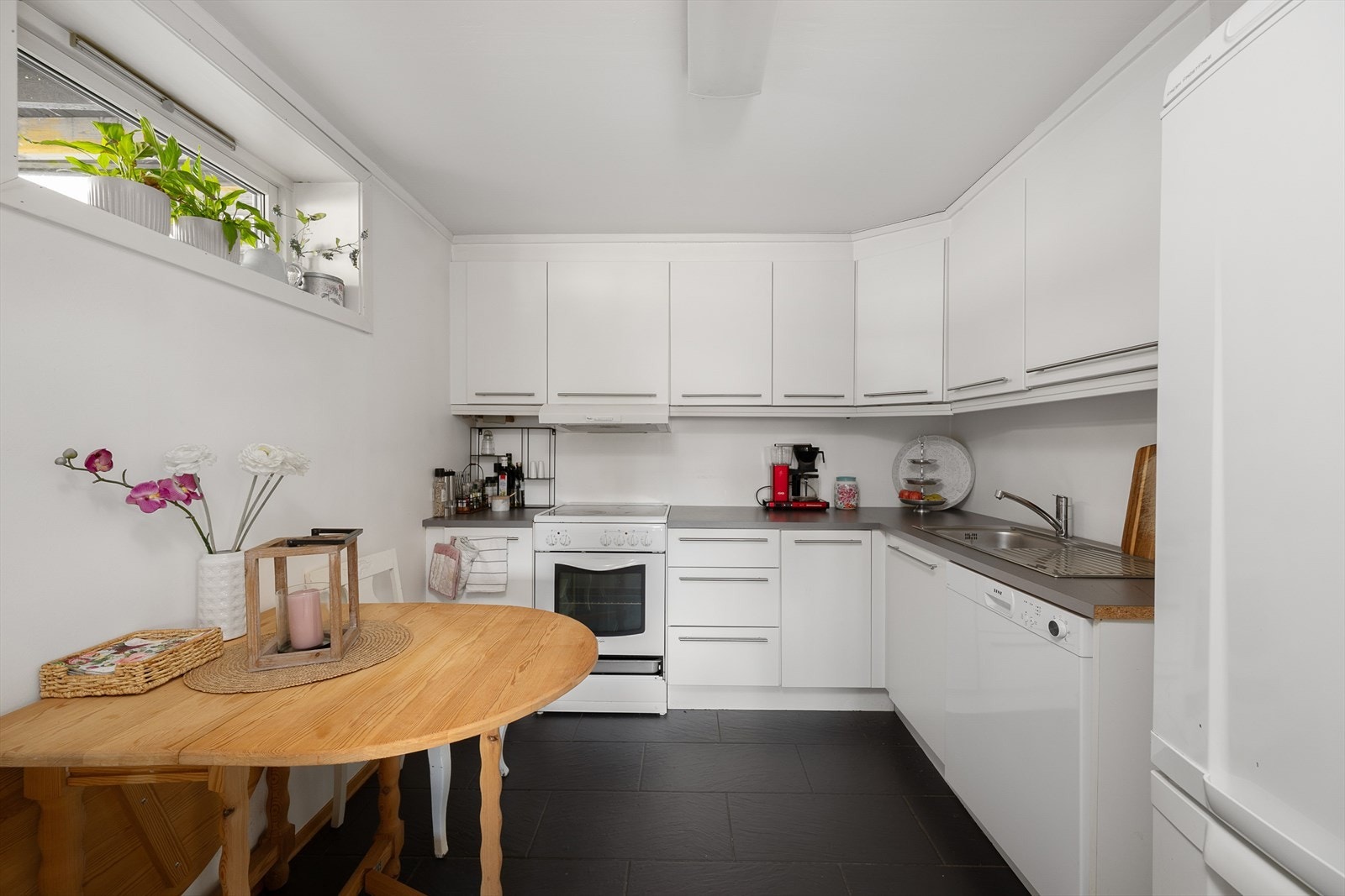 Kjøkkenet i utleieleiligheten har en pen innredning med glatte fronter og laminat benkeplate. Galleribilde