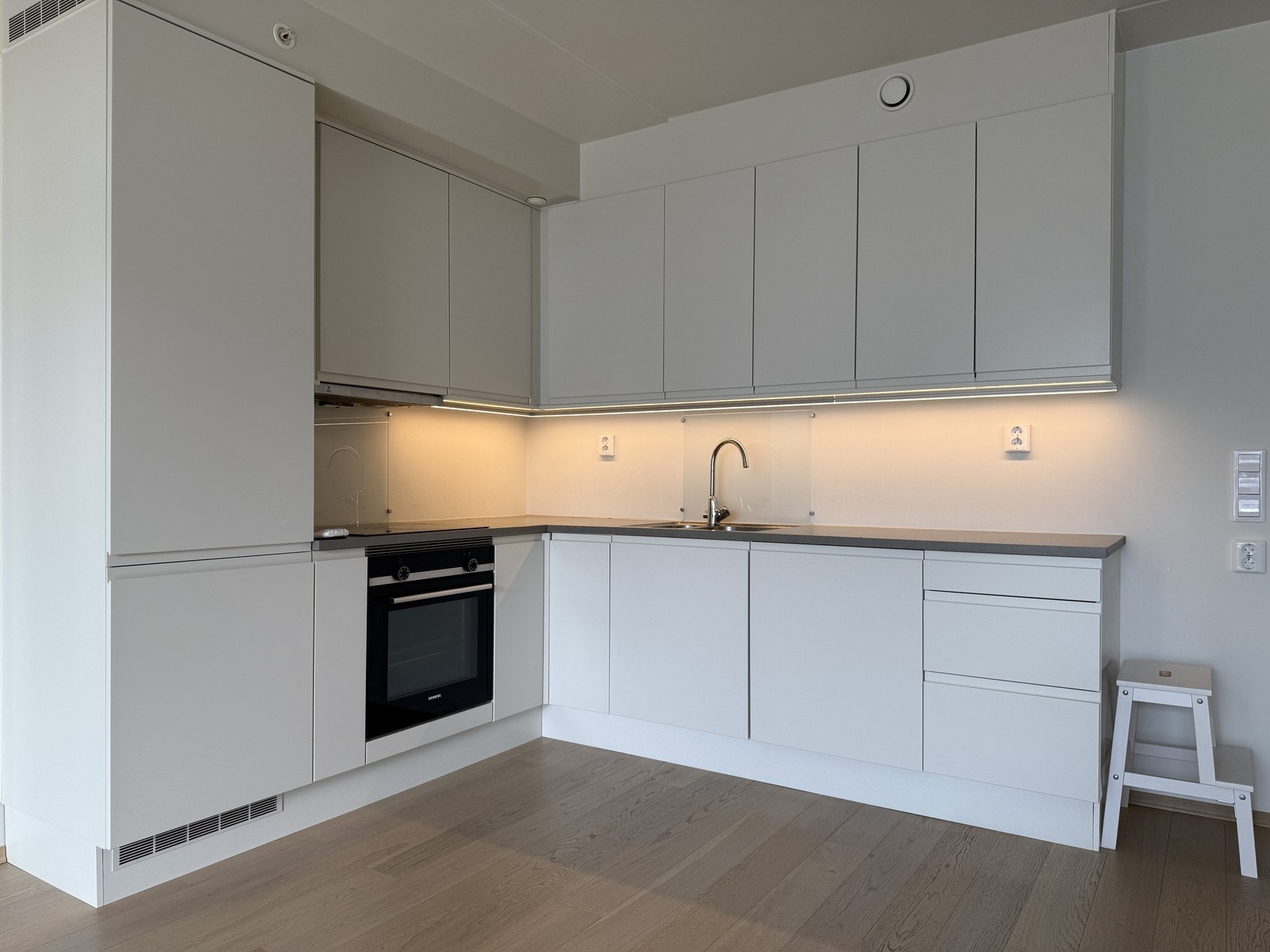 Flott kjøkken med hvite fronter. Godt med skap og benkeplass Galleribilde