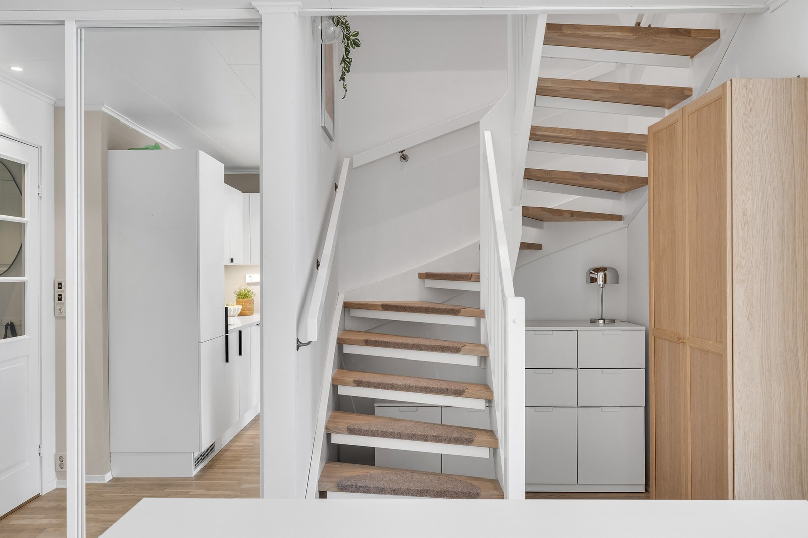 Trapp opp til 2. etasje. Det er oppbevaring i skyvedørsgarderobe og mulighet for oppbevaring under trappen. Galleribilde