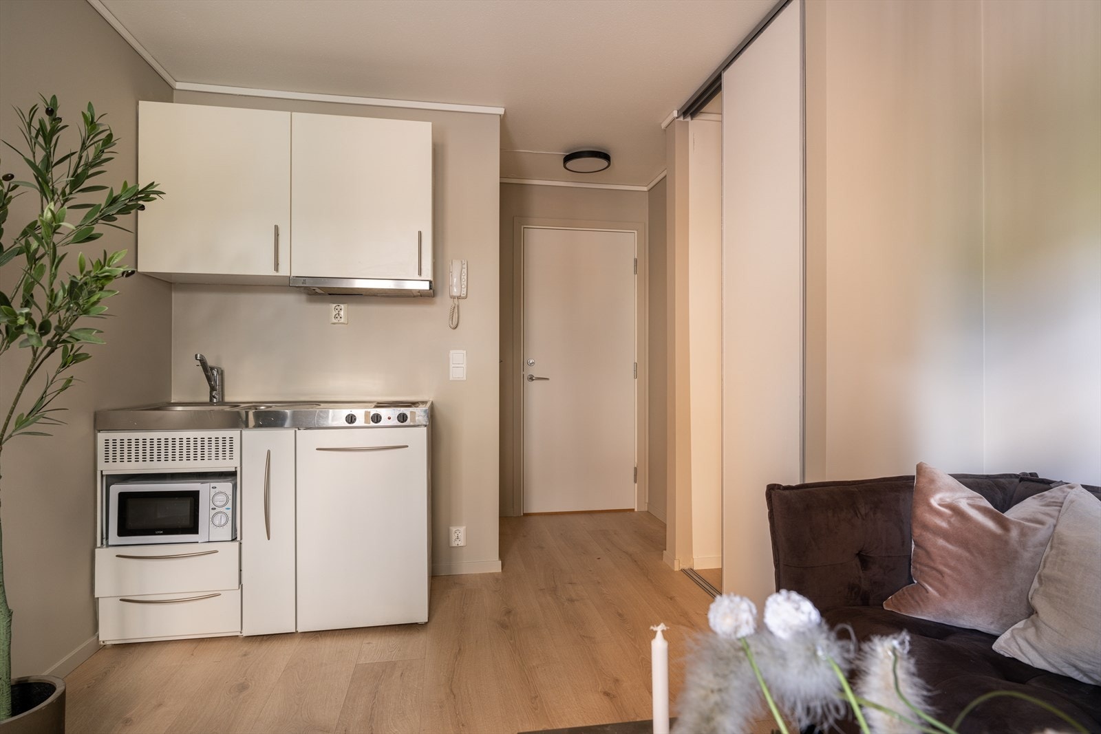 Pent kjøkken med glatte fronter og benkebeslag med vaskekum i rustfritt stål. Galleribilde