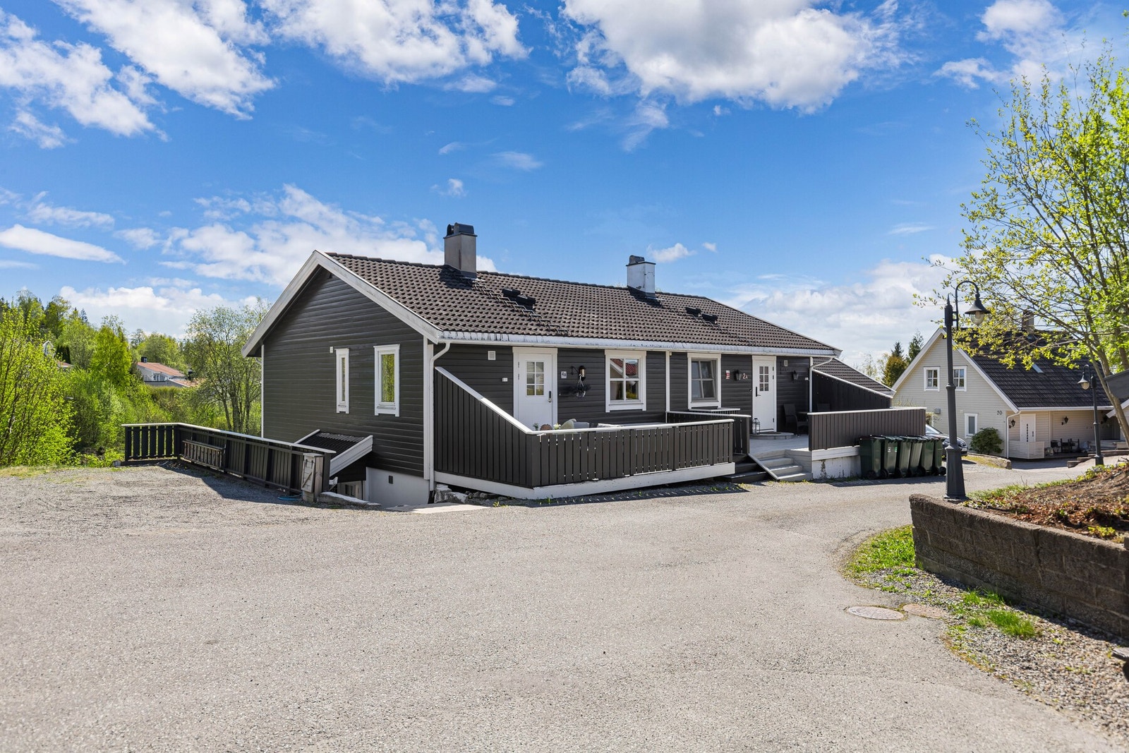 Det er parkering på to biloppstillingsplasser med en elbil lader. Galleribilde