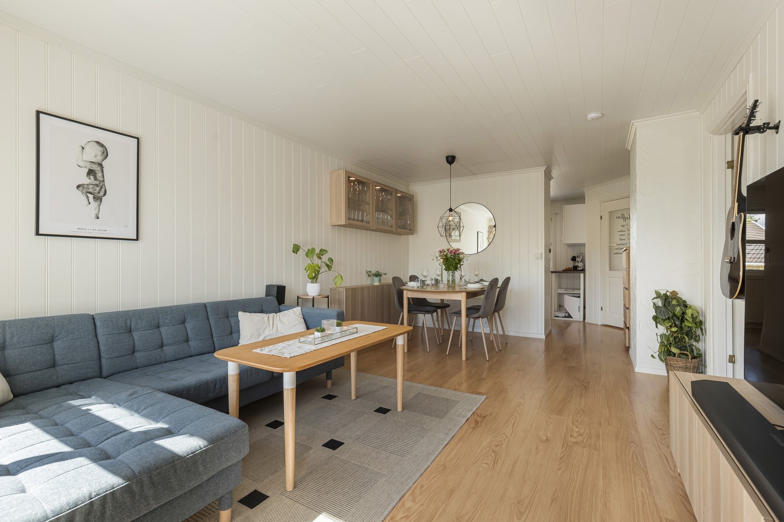 Stuen har pent laminatgulv og lysmalte panelvegger som gir et moderne og tidløst uttrykk. Galleribilde