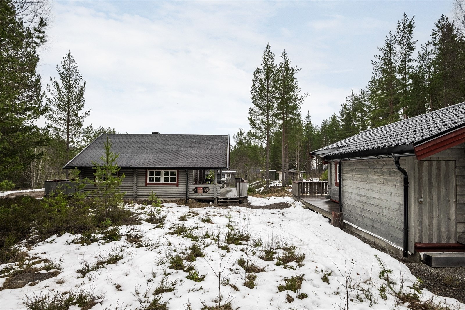Tomt på ca. 2 135,6 m² med grusede biloppstillingsplasser og kupert naturtomt. Galleribilde