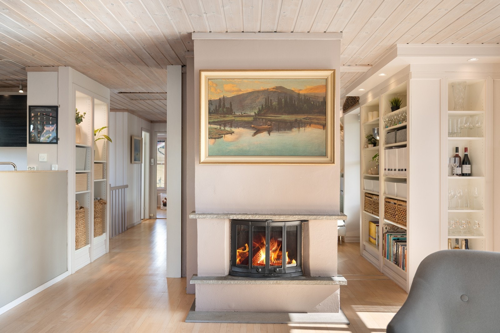 En moderne, frittstående peisinnsats fungerer som et naturlig midtpunkt. Galleribilde